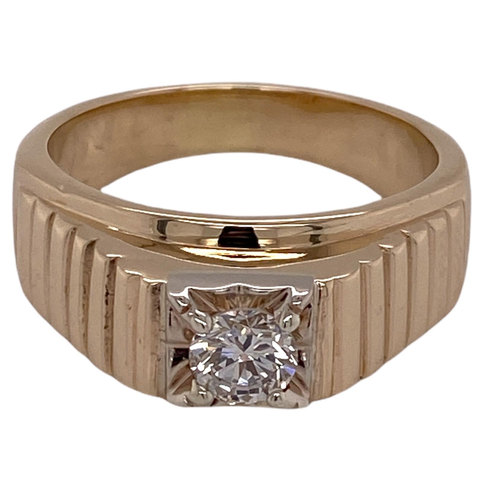 Men's solitaire diamond ring fashioned in 14 karat yellow gold. The ribbed men's ring features an approximately .65 carat round brilliant cut diamond graded K color and SI1 clarity. The ring measures 10mm in width and is currently size 12.5 (can be