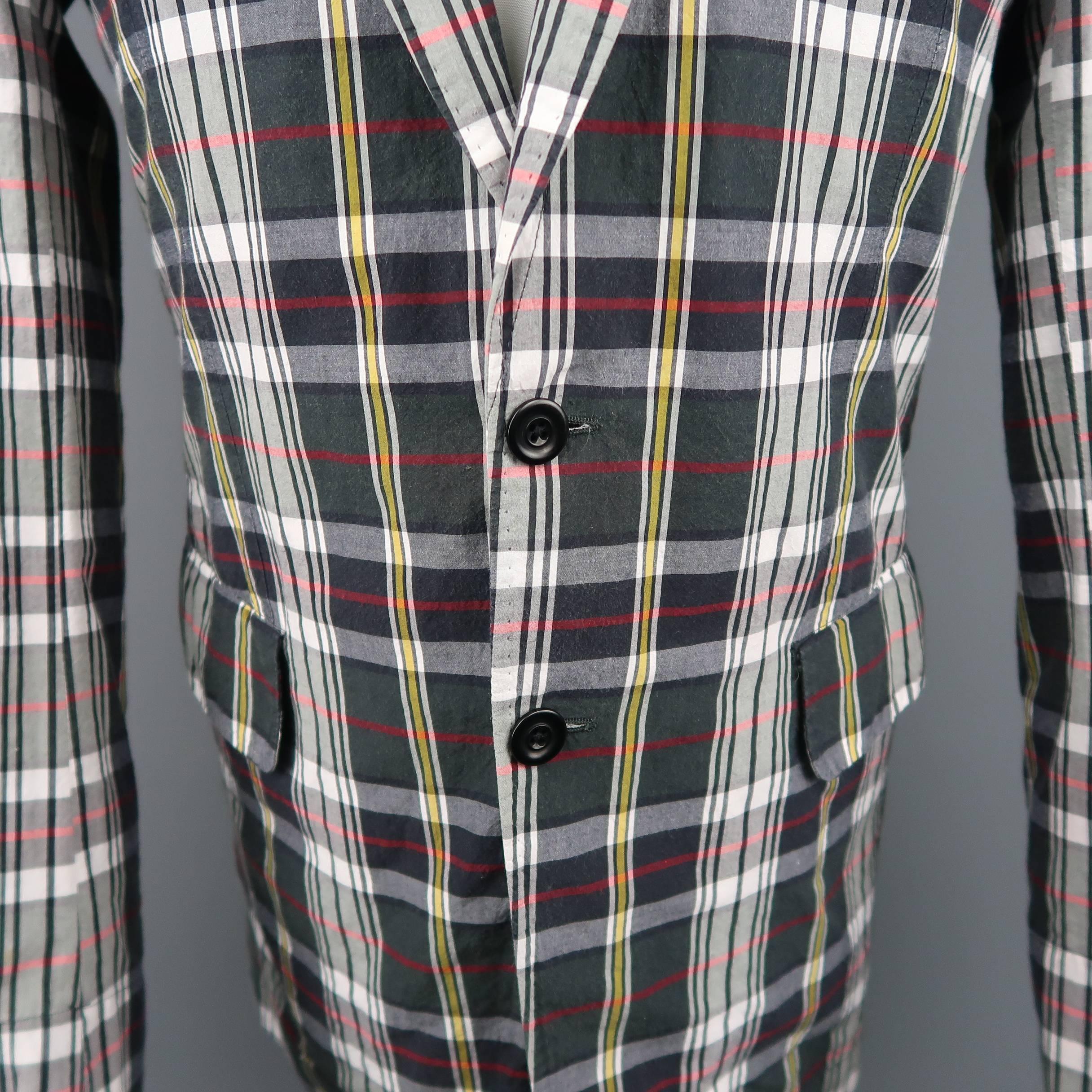 Single breasted DRIES VAN NOTEN sport coat comes in a washed effect charcoal and white plaid textured cotton with yellow and red details with a notch lapel, two button front, and top stitch details throughout. Made in Slovenia.
 
Good Pre-Owned
