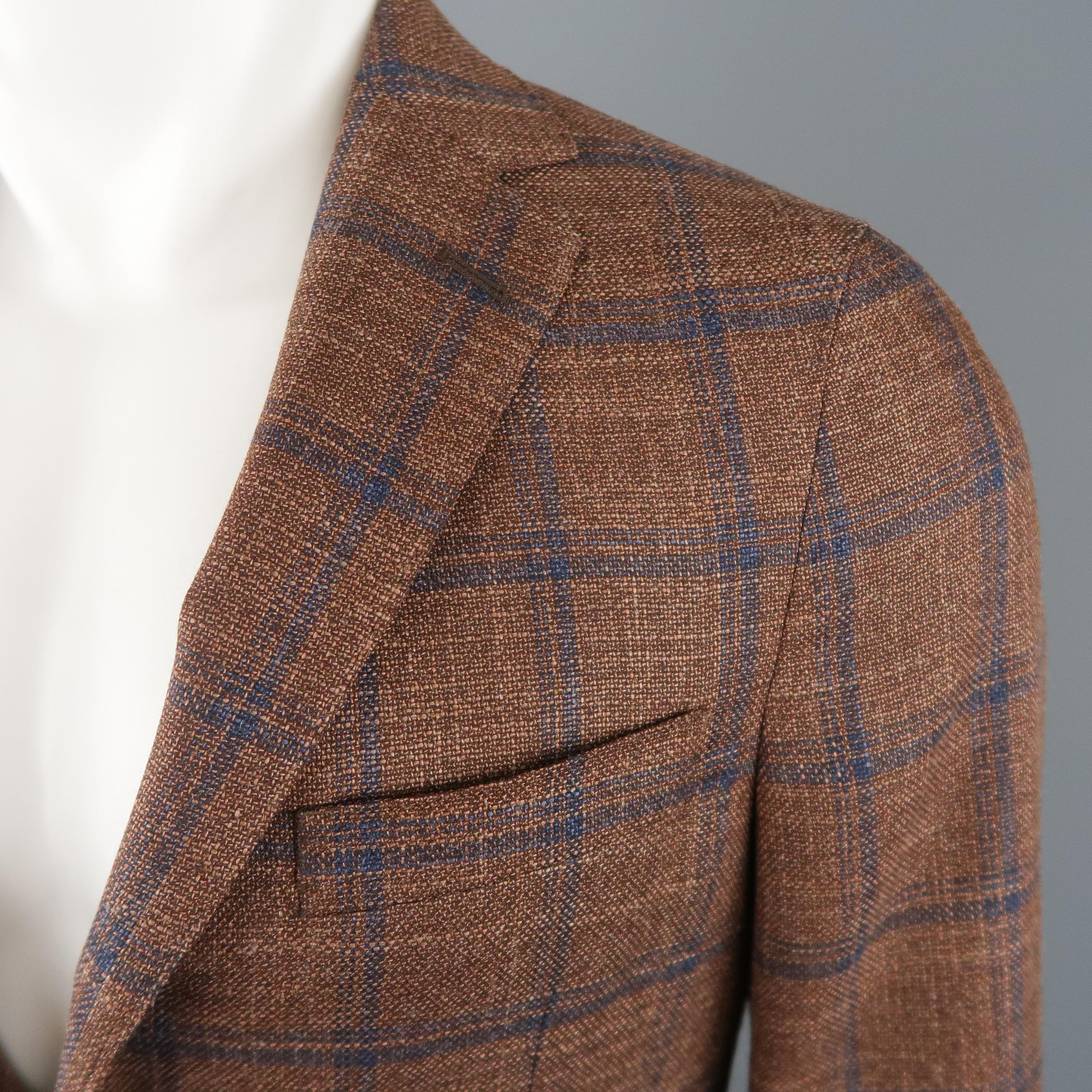 EREDI PISANO sport coat comes in bronze brown wool silk woven fabric with an all over navy blue window pane print, notch lapel, single breasted, two button closure, and double vented back. Made in Italy.
 
New with Tags.
Marked: IT 48
