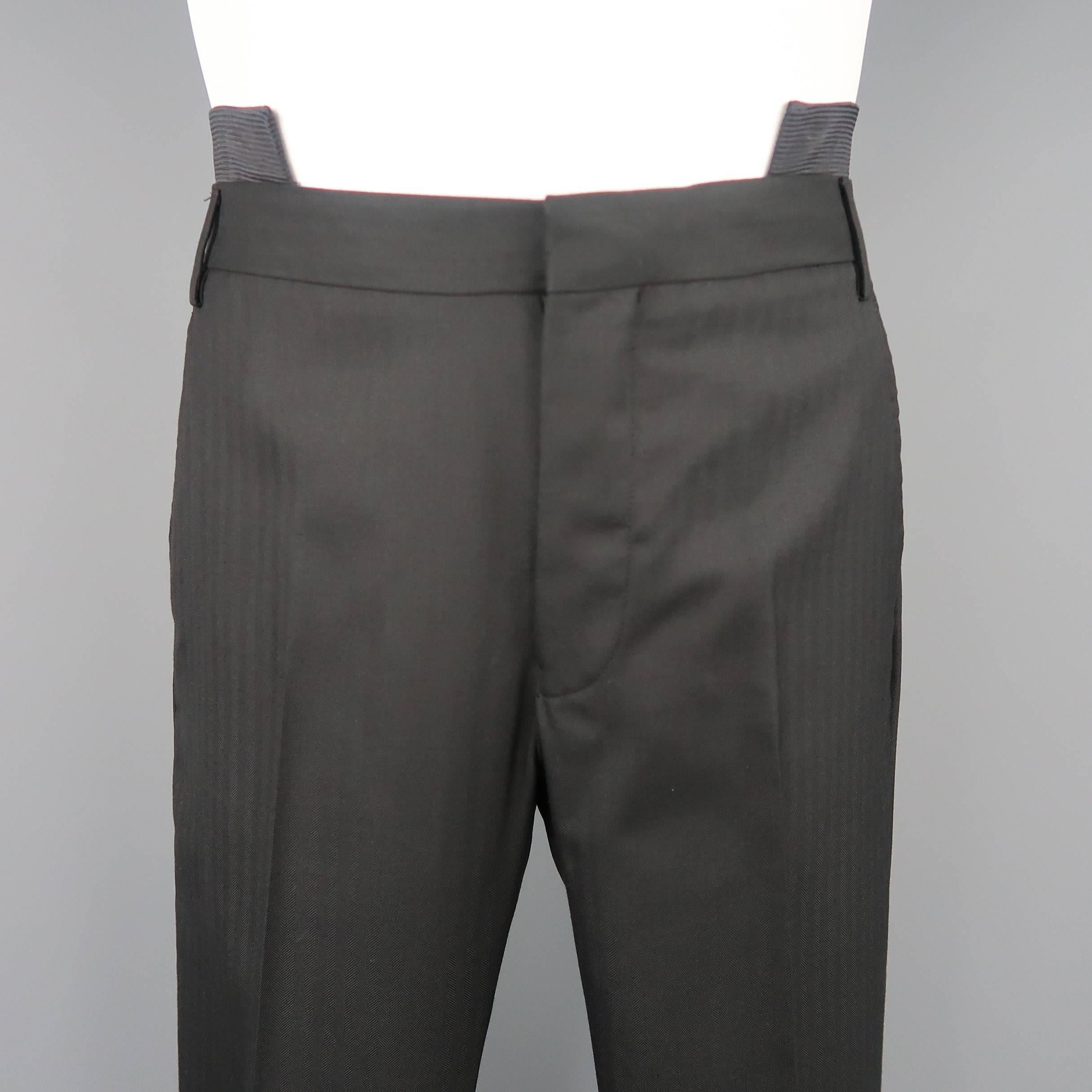 GIVENCHY by RICCARDO TISCI dress pants come in black herringbone textured wool with a slim leg, covered back buttons, and iconic Tisci double stacked cutout waistband. Featured in the Fall Winter 2010 campaign. Altered waist. See detail shots.