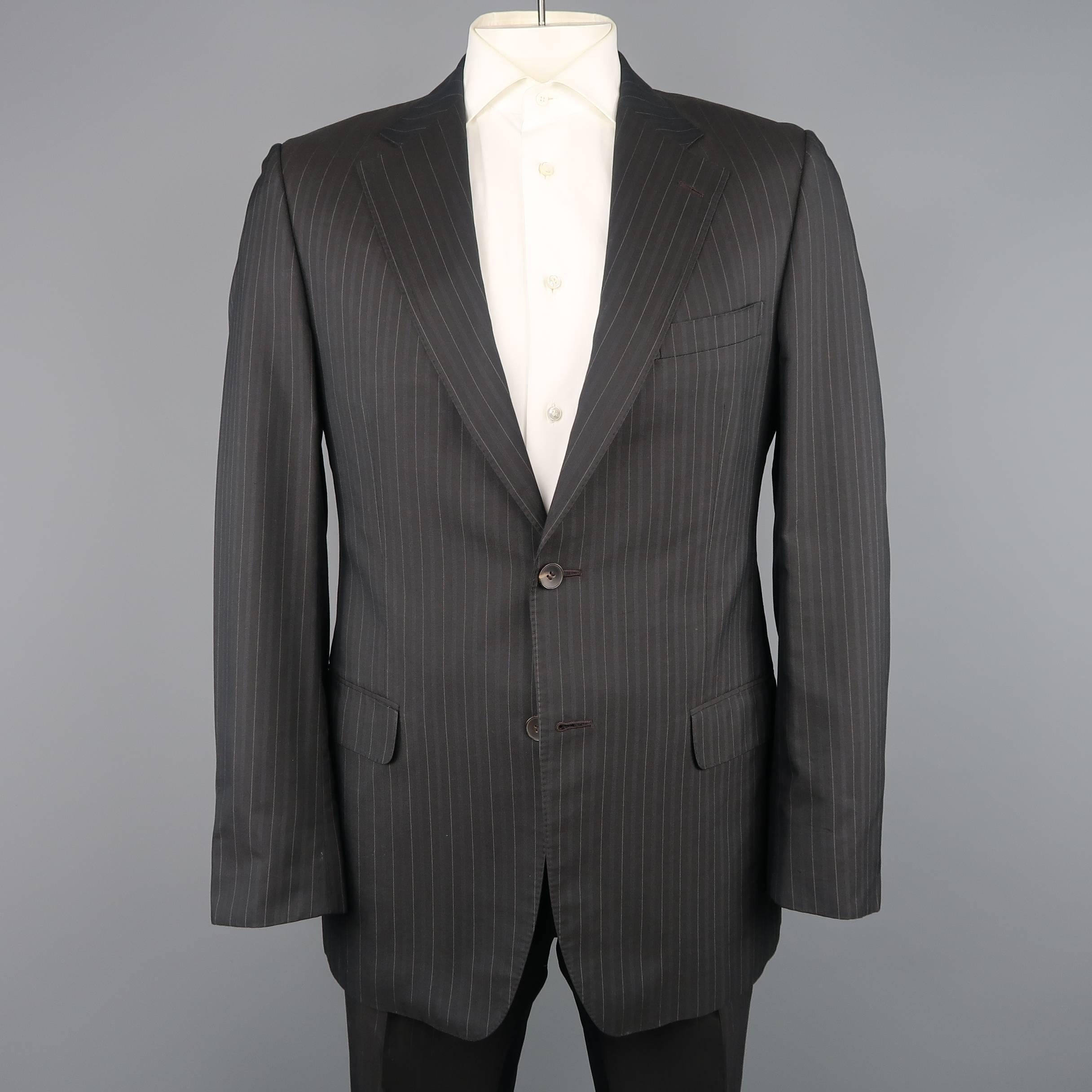 Two piece GUCCI suit comes in charcoal gray pinstripe wool silk blend fabric and includes a single breasted two button sport coat with matching flat front trousers. Minor wear. Made in Switzerland.
 
Good Pre-Owned Condition.
Marked: IT 52
