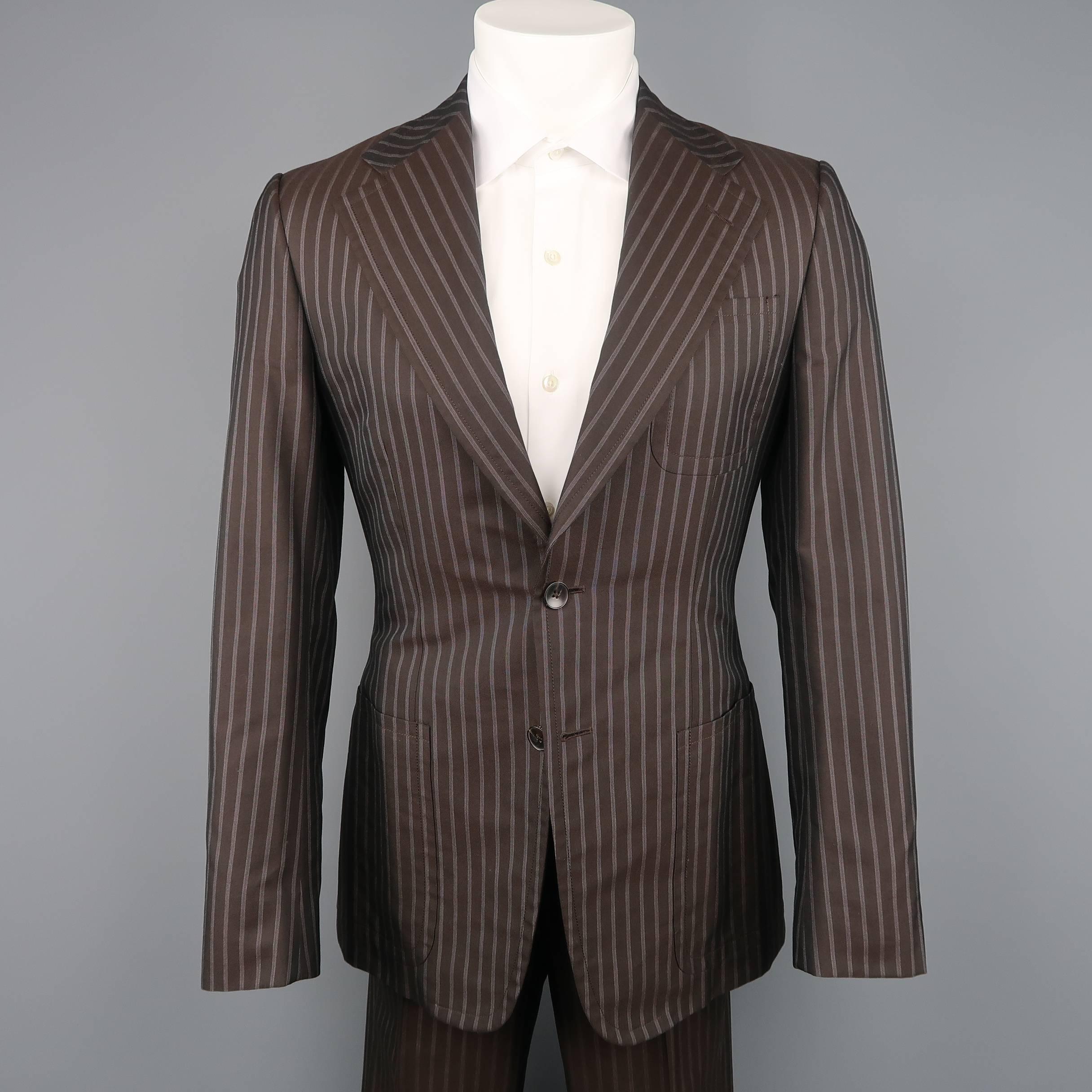 Two Piece GUCCI suit comes in chocolate brown pinstripe cotton silk blend fabric and includes a two button, patch pocket sport coat with wide notch lapel and matching flat front trousers. Made in Italy.
 
New with Tags.
Marked: IT 46 R
