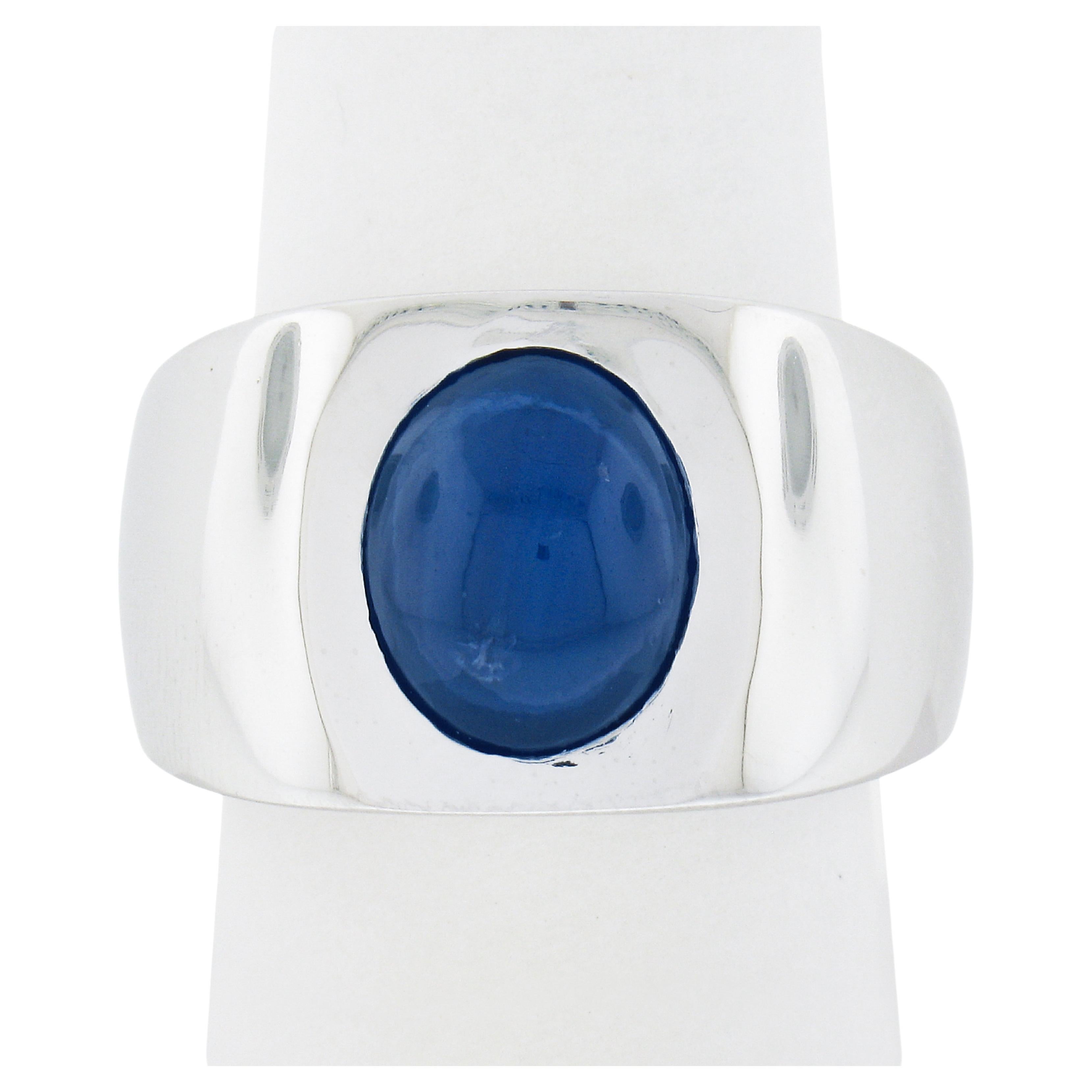 This gorgeous and very well made ring is newly crafted in solid platinum and features a magnificent, Gubelin certified, natural sapphire stone perfectly bezel set at its center. The oval cabochon cut sapphire is certified as weighing exactly 9.01