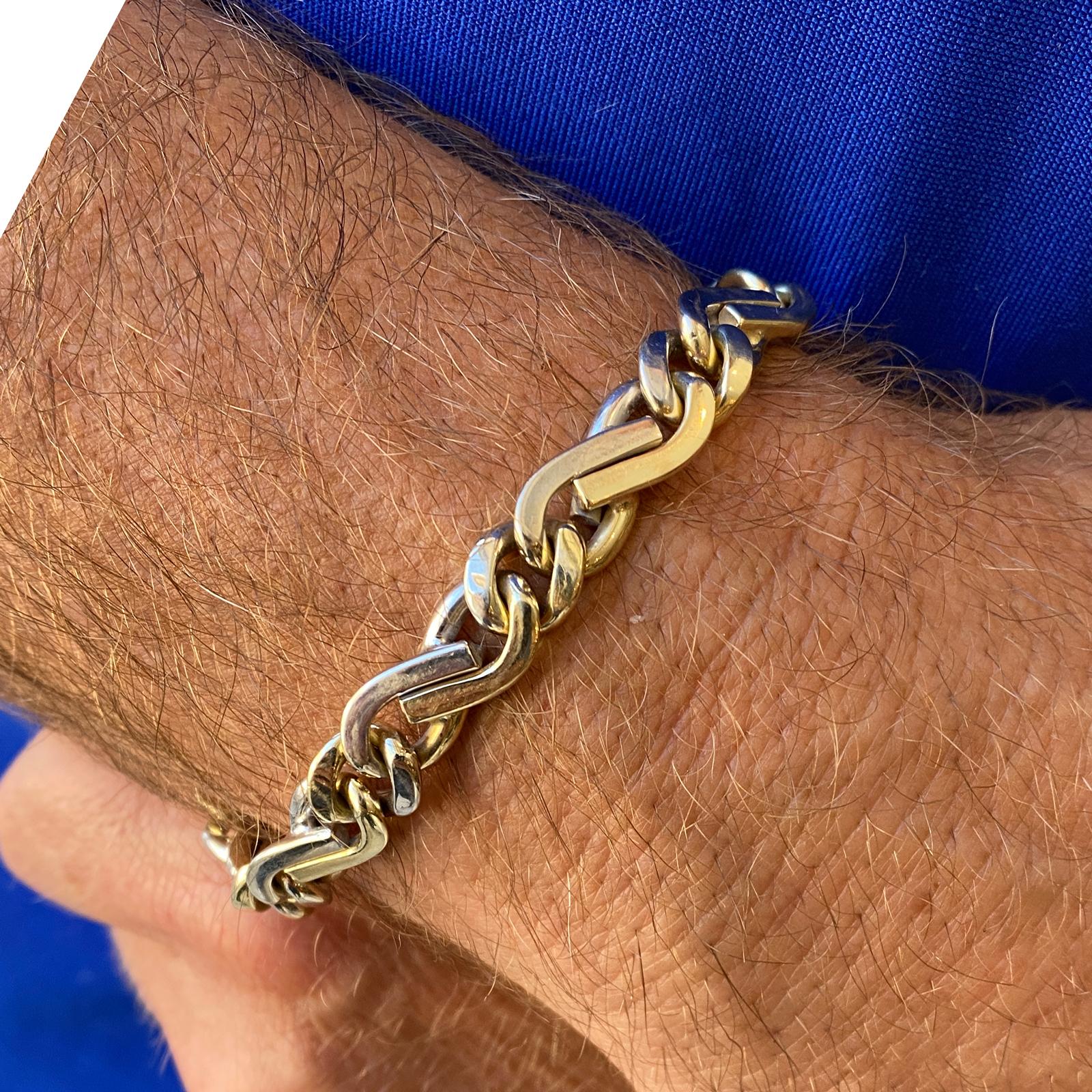 Men's Italian link bracelet fashioned in 14 karat two tone gold. The bracelet measures 8.5 inches in length and .40 inches in width. 