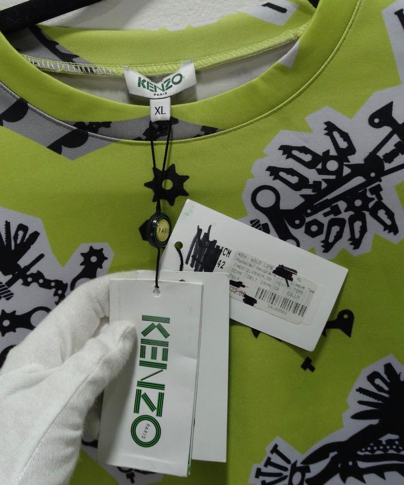 This lime green graphic printed Kenzo top is so special and fun! Featuring a black and white abstract print throughout,  this shirt is perfect to match with your every day black or white pants to add in a pop of color.  Style this with some black