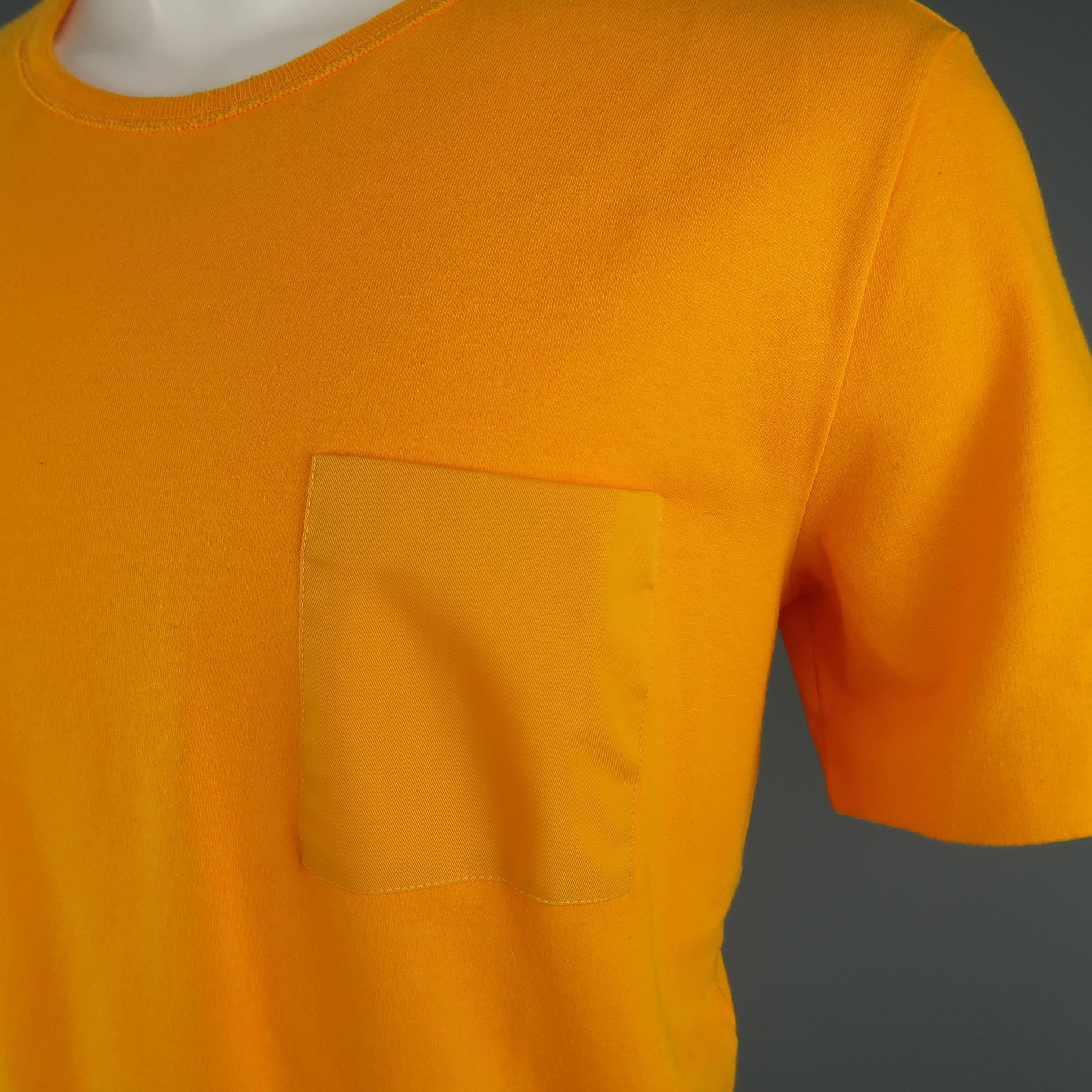 MAISON MARTIN MARGIELA T shirt comes in bold citrus goldenrod orange yellow jersey with a round neck, nylon twill breast pocket, and signature white stitches at back. Made in Italy.
 
Excellent Pre-Owned Condition.
Marked: IT 50
 
Measurements:
