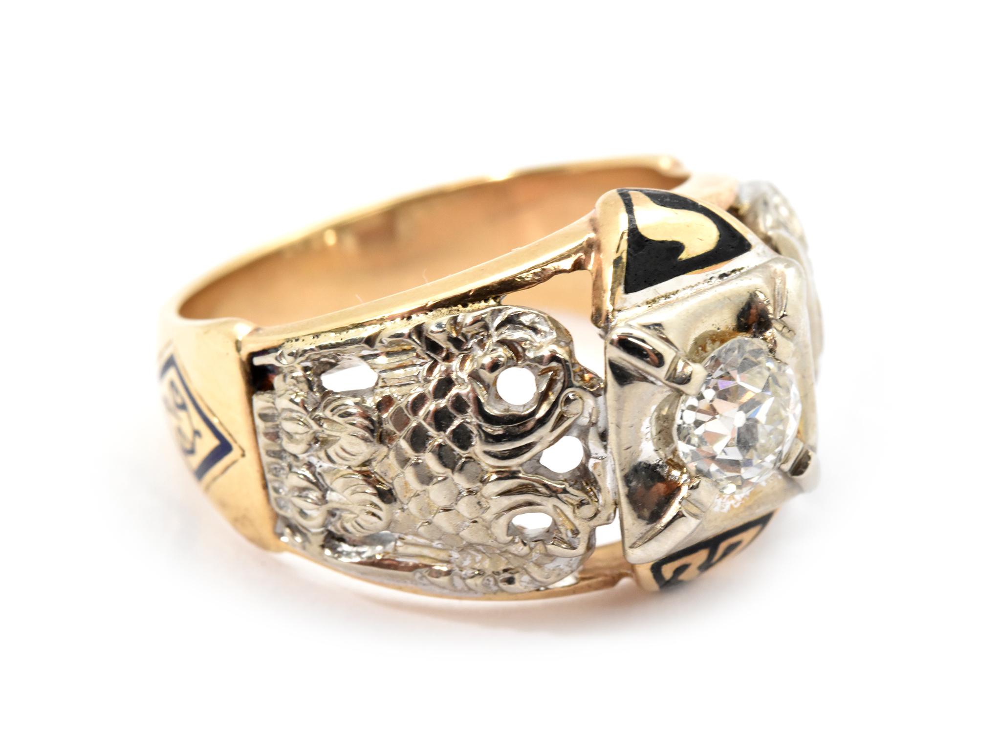 This ring is made in 10k yellow gold, and it holds a round brilliant diamond accented by Masonic symbols. The diamond weighs about 0.50ct, and it is graded I in color and SI1 in clarity. The ring measures 14mm wide, and it weighs 8.9 grams. The ring