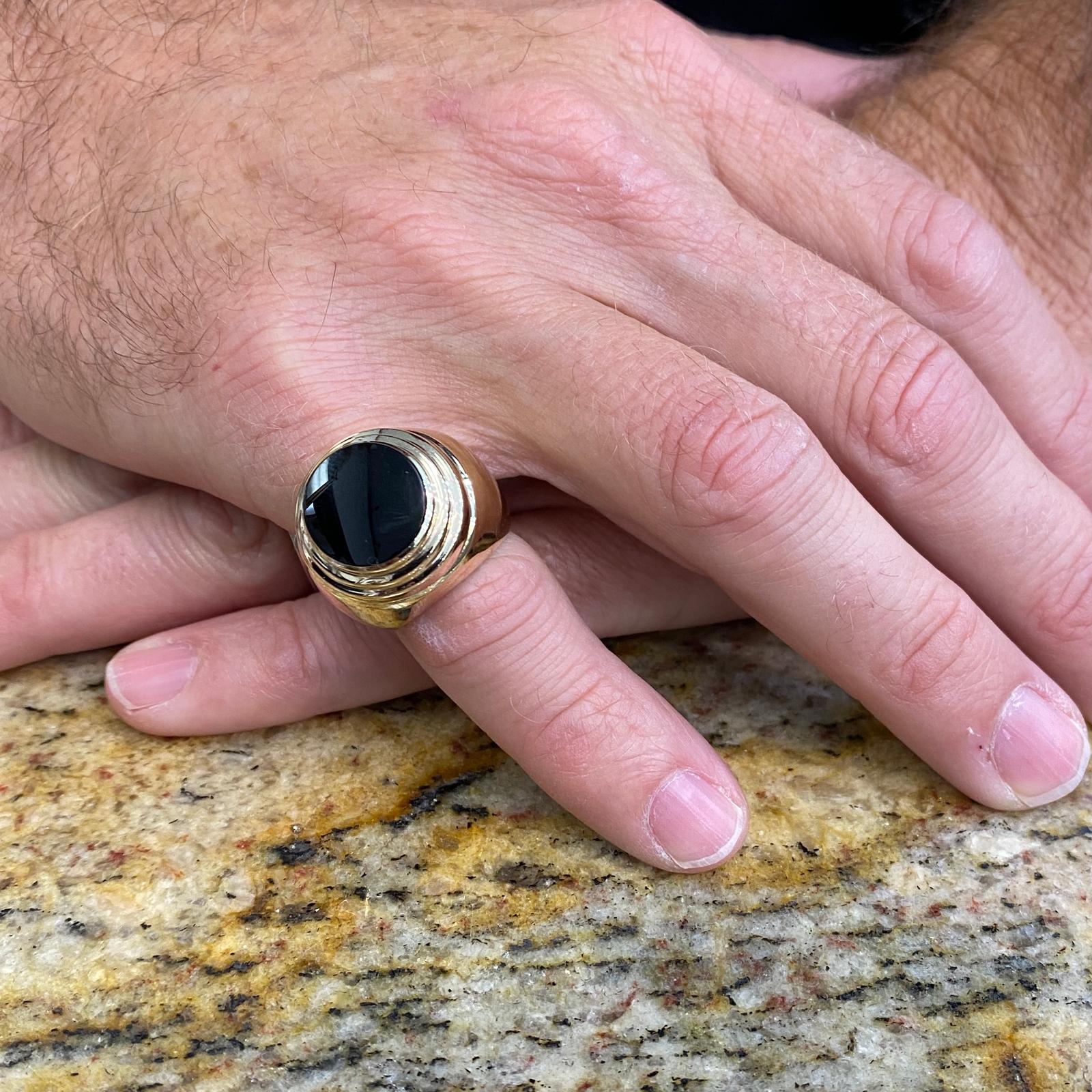 Men's onyx pinky ring fashioned in 14 karat yellow gold. The ring measures 20mm in width and is currently size 5.75 (can be sized). 