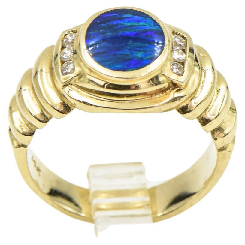 Large 14k fluted yellow gold ring featuring a bezel set oval opal doublet accented by 3 round diamonds on either side.  The opal measures approximately 9mm x 7mm.  The ring is marked 14k.  The weight of the ring is 6.89 dwt.  The total diamond