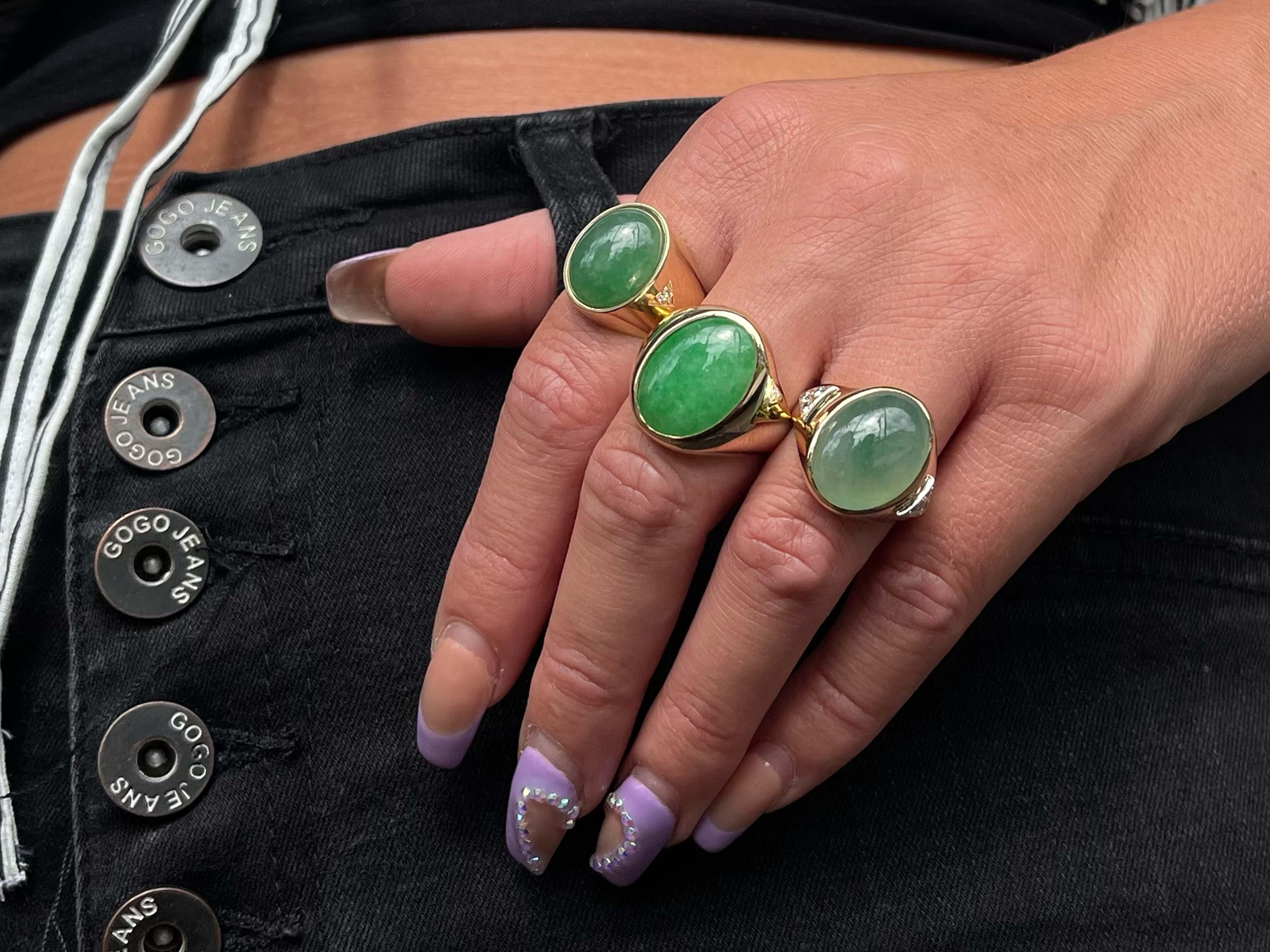 Men's Oval Green Jade Diamond Ring in 18k Yellow Gold. This stunning jade has a beautiful translucency that reflects light brining the jade to life. The Jade measures approximately 15.76 mm x 12.32 mm x 6.73 mm. The ring has a total of 2 round