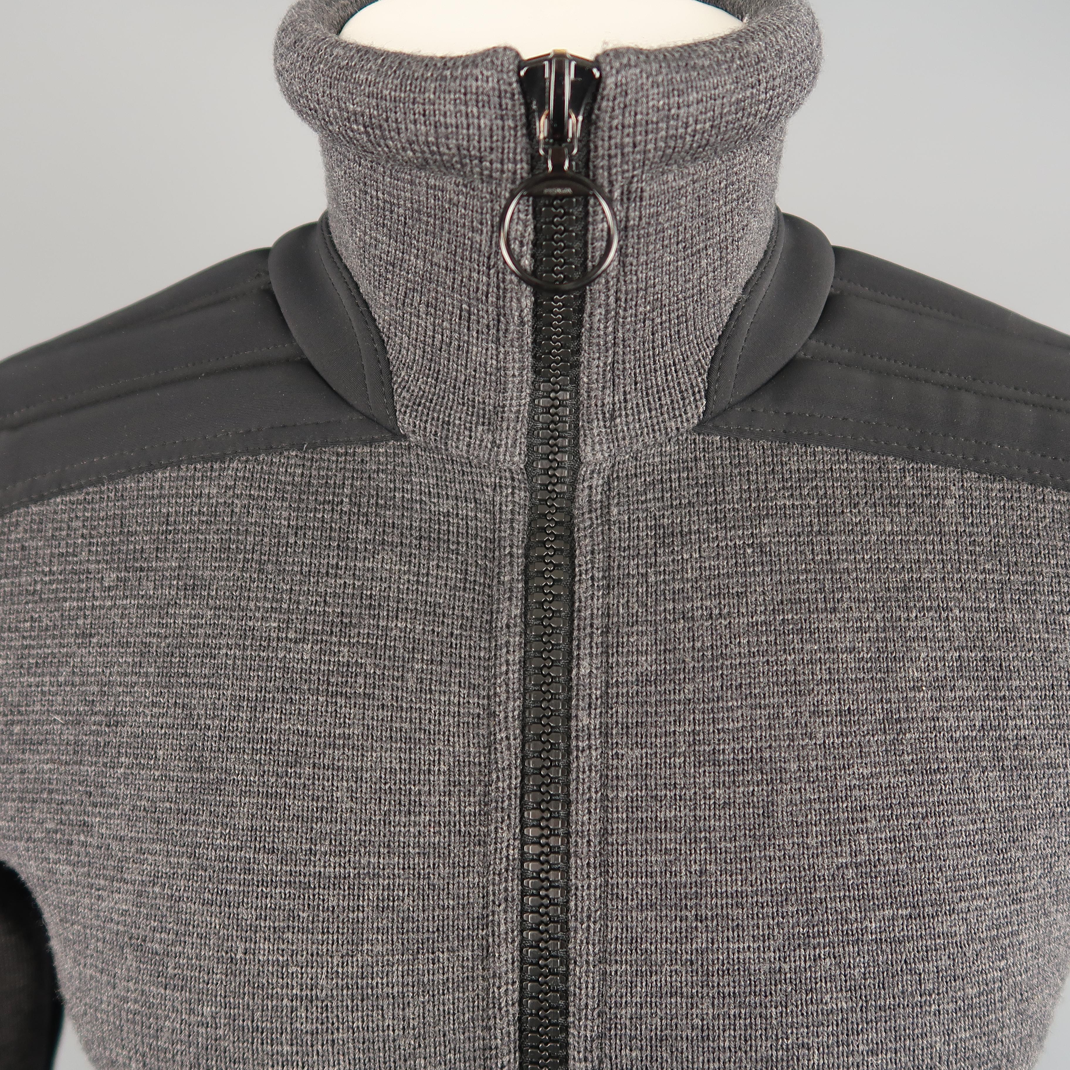 PRADA jacket comes in gray wool knit with a high collar, double zip front, and padded nylon moto detailed sleeves. Hole on back. As-is.
 
Good Pre-Owned Condition.
Marked: IT 48
 
Measurements:
 
Shoulder: 16 in.
Chest: 39 in.
Sleeve: 25 in.
Length:
