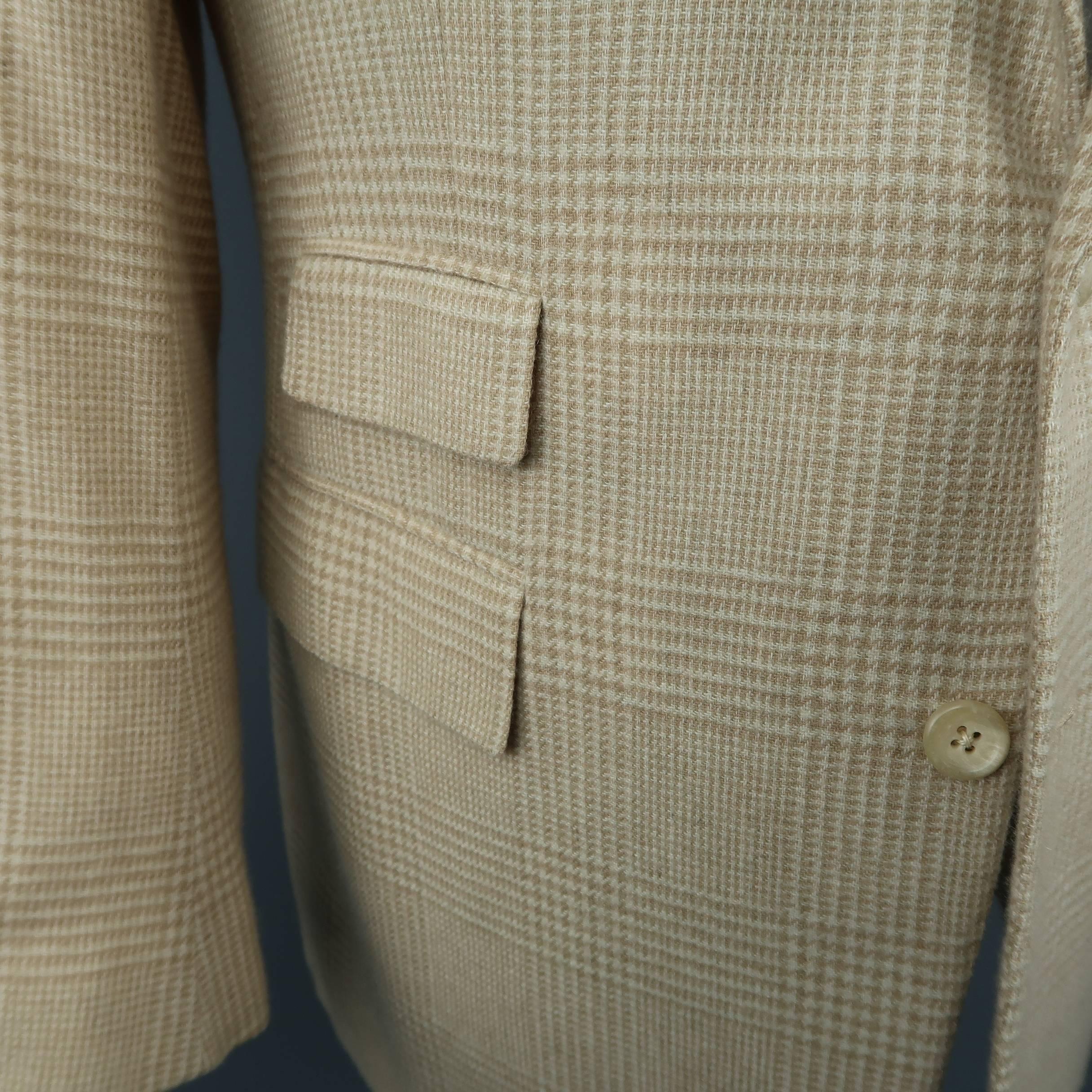 Ralph Lauren Purple Label sport coat comes in khaki and tan glenplaid cashmere with a notch lapel, two button front, triple flap pockets, functional button cuffs, and double vented back. Made in Italy.
 
Excellent Pre-Owned Condition.
Marked: 40
