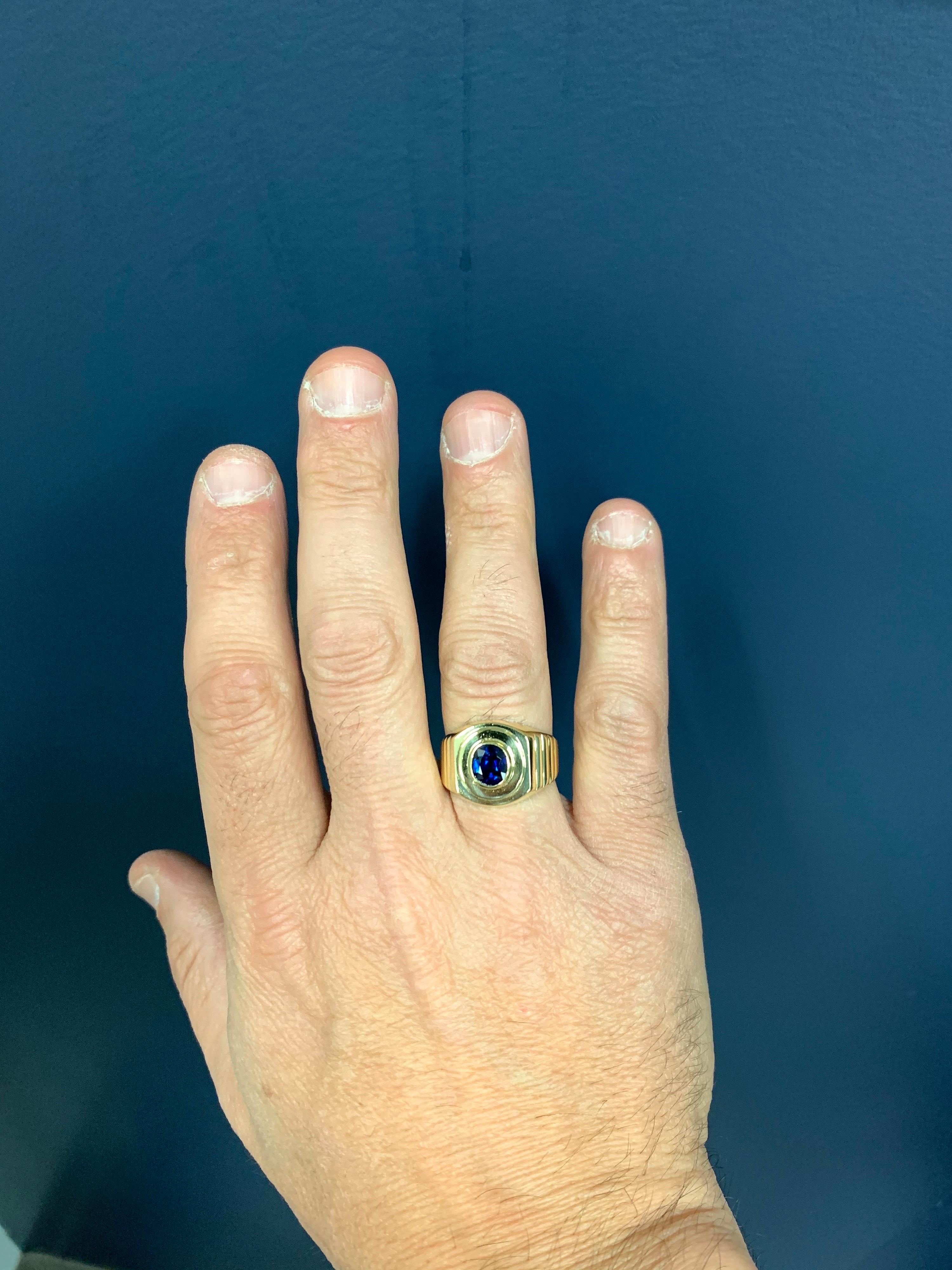 Men’s Retro 18k Yellow Gold Estate Ring.

Set with a 2 Carat (approximate) Cushion Natural Deep Blue Sapphire Gem Stone measuring approximately 8x6.9x4.3mm.

The stone is heated and most likely with origins from Thailand. 

The weight is 13.6 grams