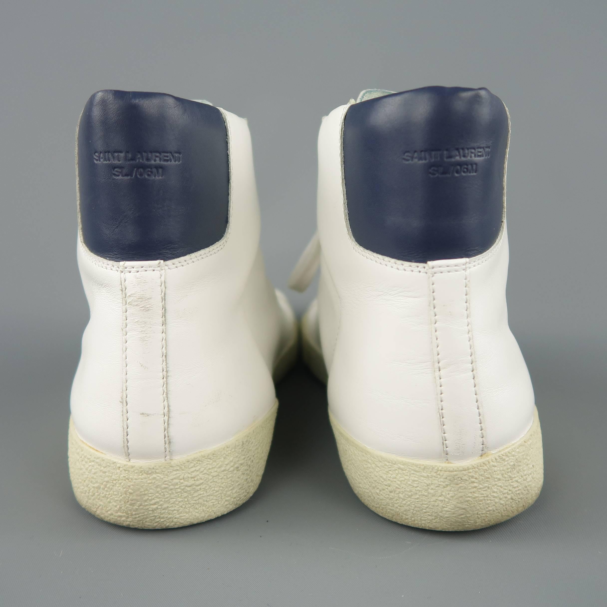 SAINT LAURENT SL/06M high top sneakers come in white leather with a beige rubber sole and a navy leather back panel. Wear throughout. As-is. Made in Italy.
 
Fair Pre-Owned Condition.
Marked: IT 43
 
Outsole: 11.5 x 4 in.
