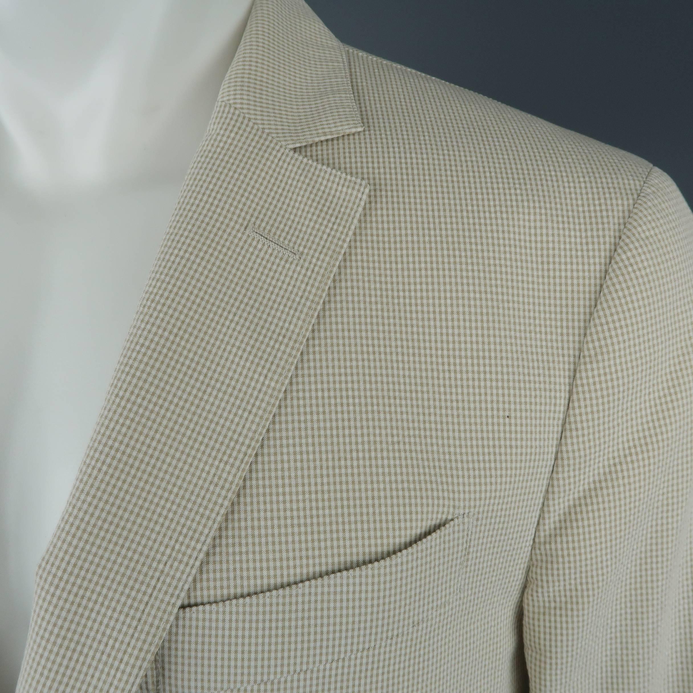 Single breasted SALVATORE FERRAGAMO sport coat comes in a light weight cream and khaki micro-gingham print textured cotton with a notch lapel, two button front, and single vented back. Made in Italy.
 
Excellent Pre-Owned Condition.
Marked: IT 50