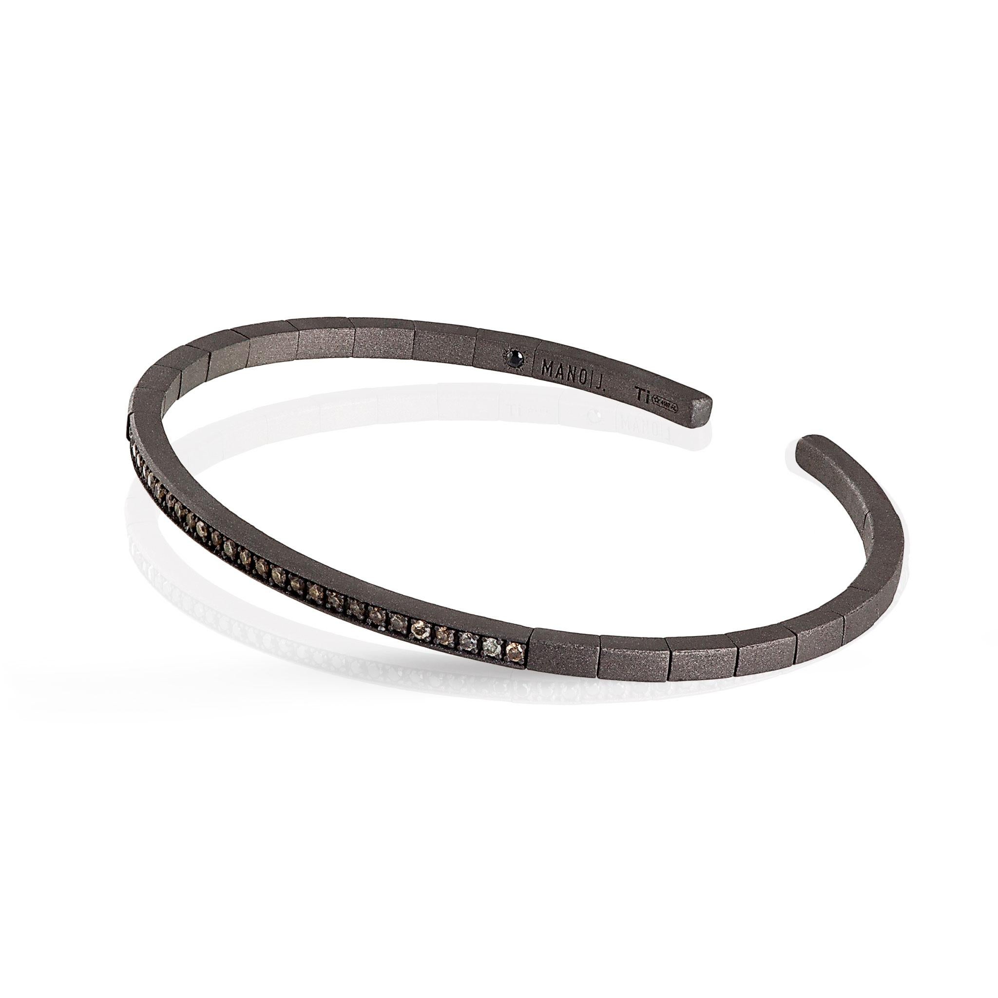 Herrenarmband aus Titan mit braunen Diamanten. Ein Armband mit elastischer Struktur und einer langen Reihe von 27 braunen Diamanten mit einem Gesamtkarat von 27 Punkten, die einen Teil des Armbands durchziehen. Auf der Innenseite ist eine schwarze