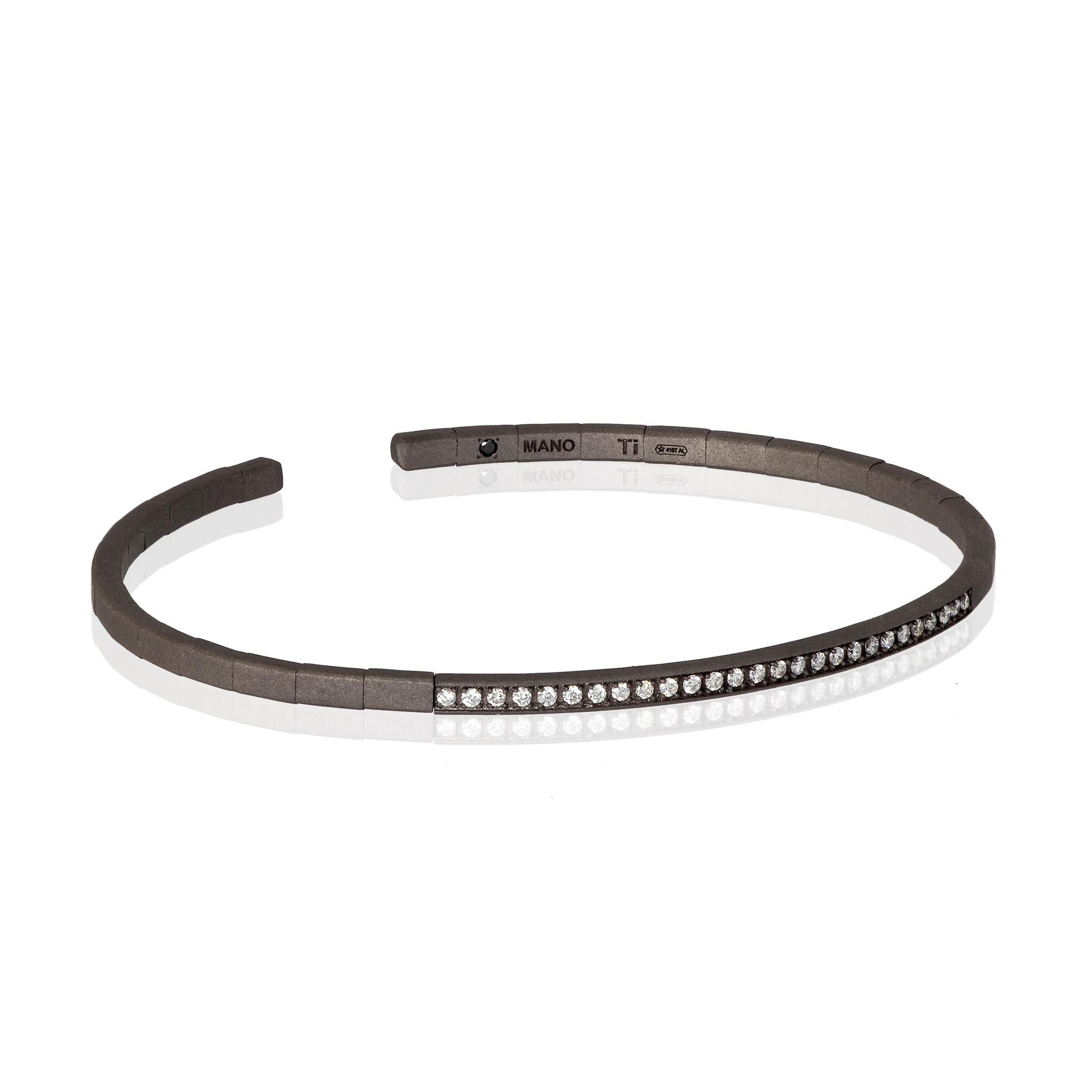 Men's titanium bracelet with white diamonds. A bracelet with an elastic structure featuring a long series of 27 white diamonds with a total carat of 27 points running through part of the bracelet. On the inside, a 1-point black diamond has been set
