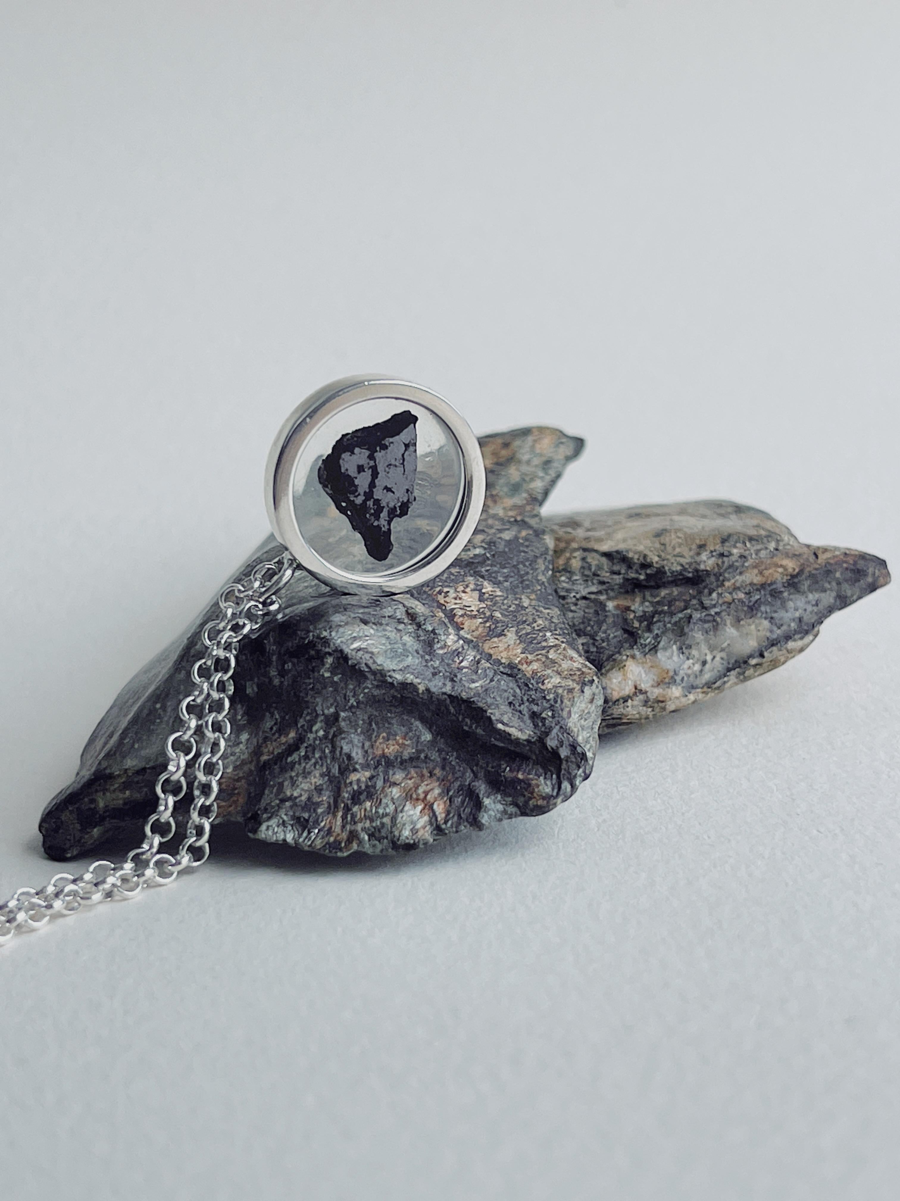 Explore the wonders of the universe with our exclusive Stardust Necklace, elegantly adorned with authentic meteorite fragments. Each necklace is a masterpiece of unique compositions, making it a truly one-of-a-kind accessory that encapsulates the