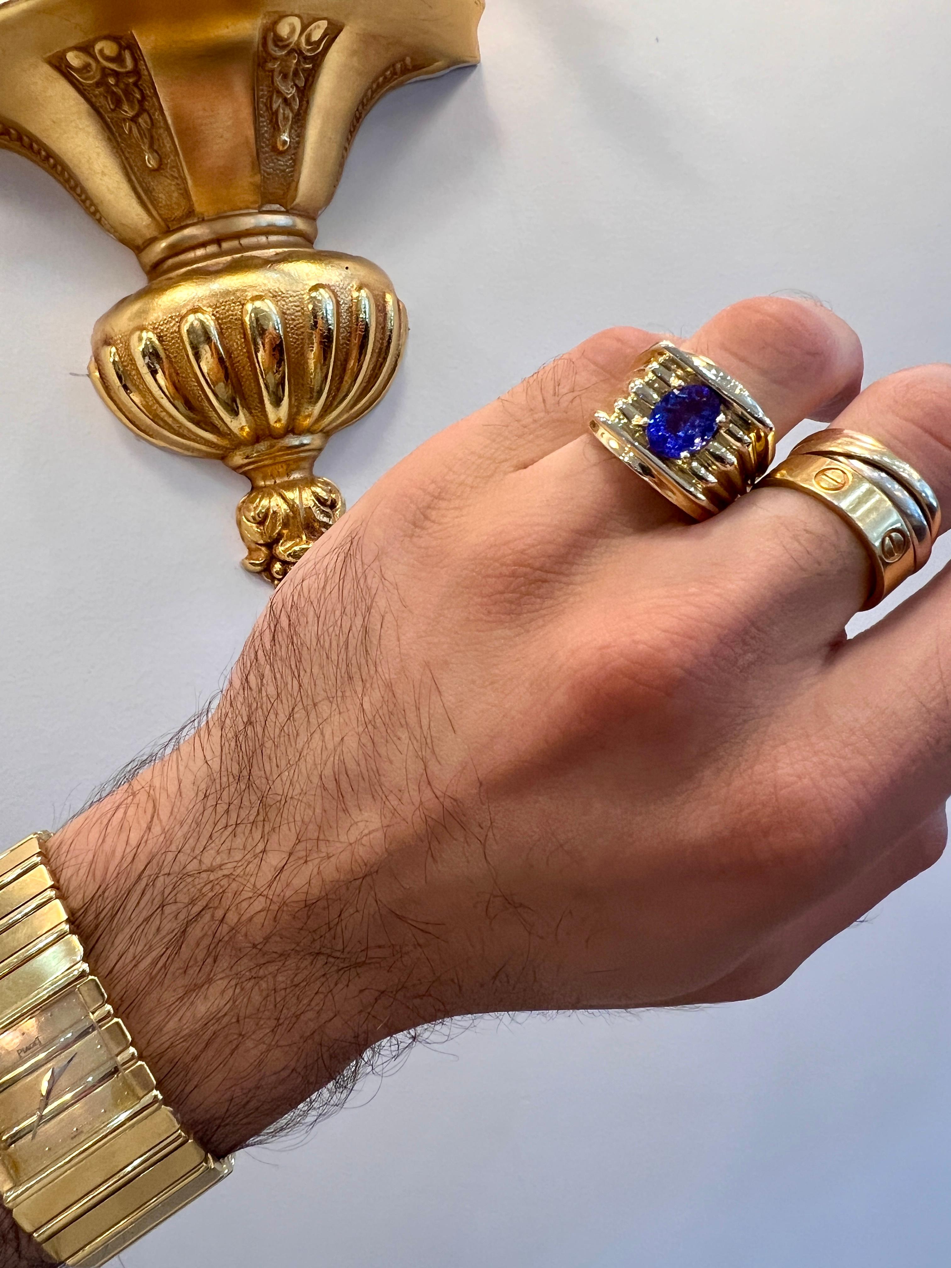 Lavish 1970s, Design Piaget Polo Inspired Mens Ring! Solid Yellow Gold 14k (585 Hallmark). Fine line detailing is emphasized on this ring, amplifying the center Oval-Cut Brillant Tanzanite. 
The center stone is approximately 2.56 carats in weight.