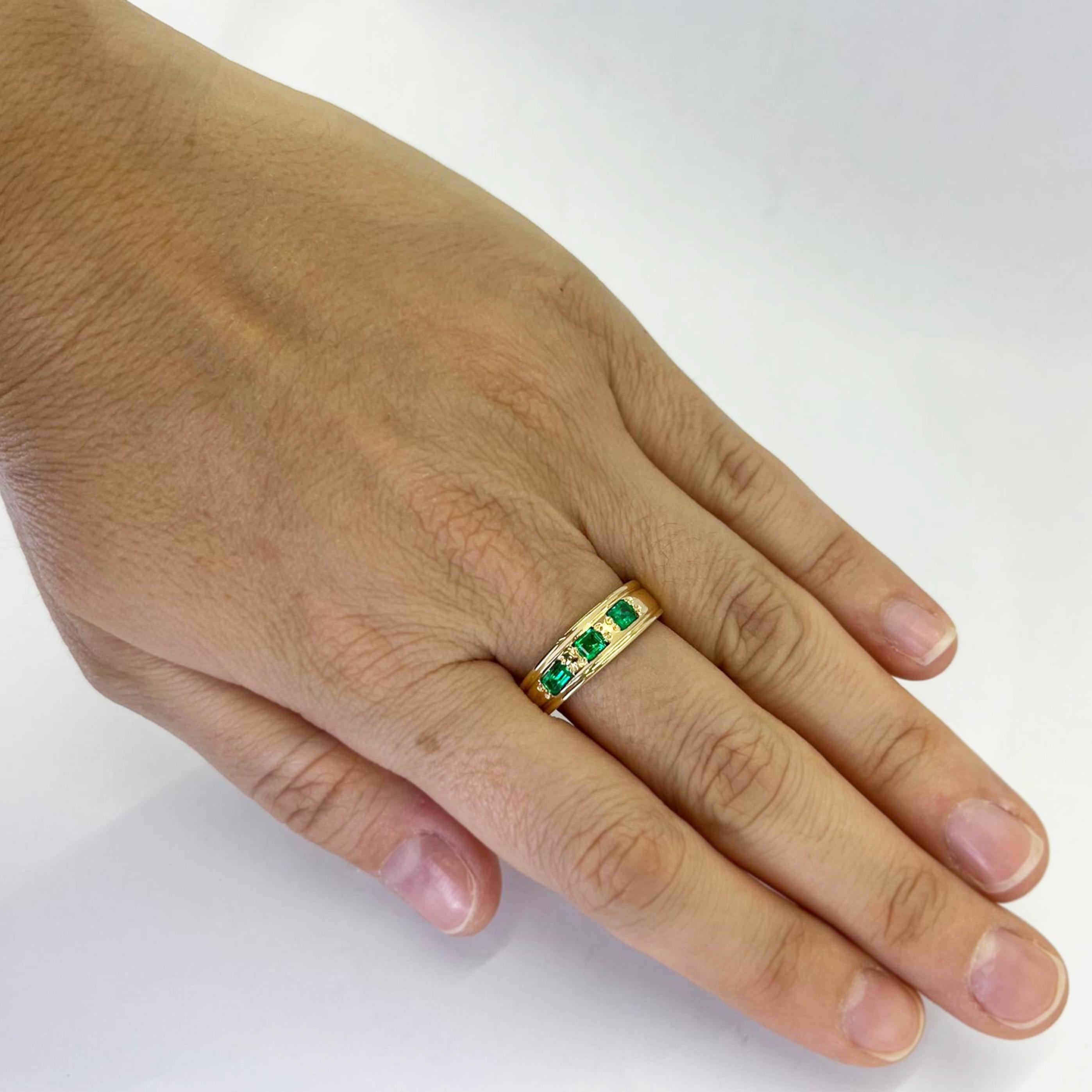 18 karat yellow gold 6.5mm band featuring 3 horizontal emerald cut emeralds totaling approximately 0.50 carats. Finger size 9 with tapered back. One sizine service included upon request, prior to shipping. Finished weight is 5.0 grams.