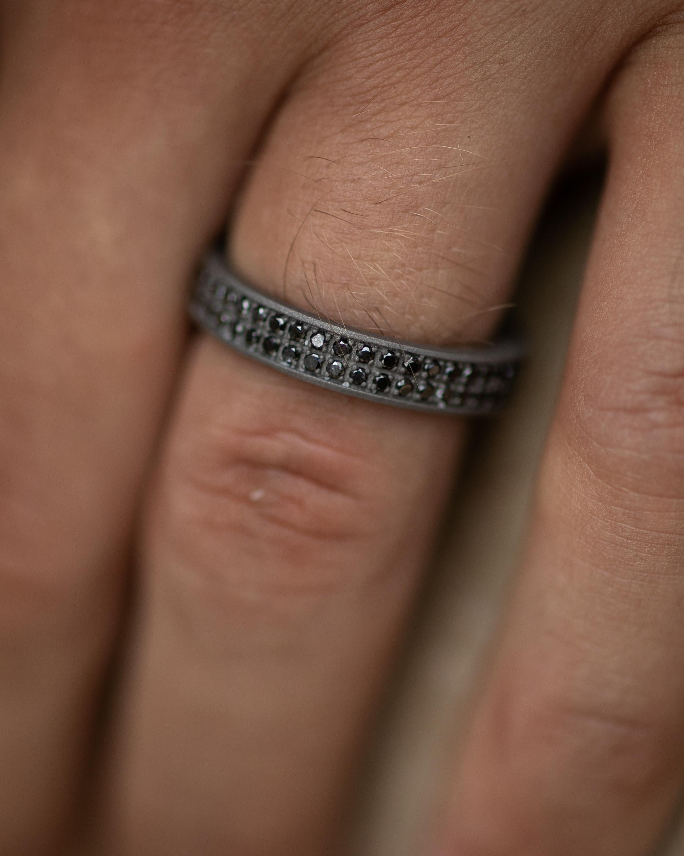Titanium band ring is from our Men's Collection. This masculine modern ring is made of 43 natural black round diamonds in total of 0.43 Carat placed along the band with stylish 18K rose gold detail. The band is 0.3cm wide. Perfect for manly