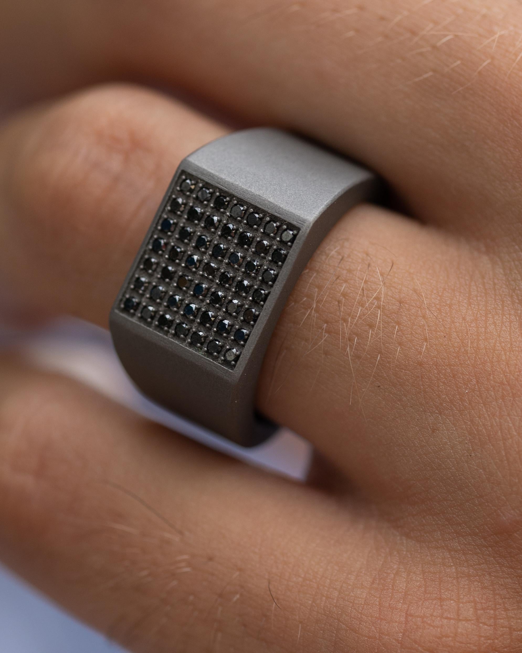Titanium signet ring is from our Men's Collection. This masculine ring is made of 49 natural black round diamonds in total of 0.49 Carat with a 18K rose gold detail on the band. The widest part of the ring is 1.2cm and the thinest is 0.6cm. Perfect