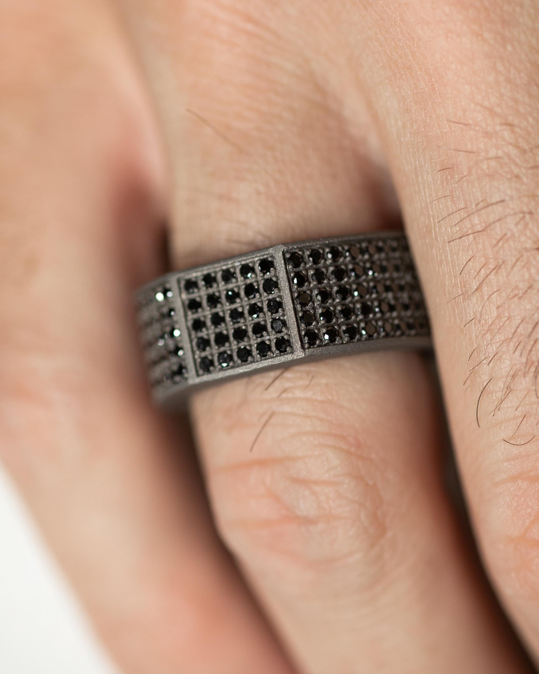 Crafted with precision and elegance, this Titanium Band Ring has been made with 225 natural black round diamonds, totaling a stunning 2.25 Carats. The band measures 1cm in width, making a unique combination of sophistication and masculinity.
The