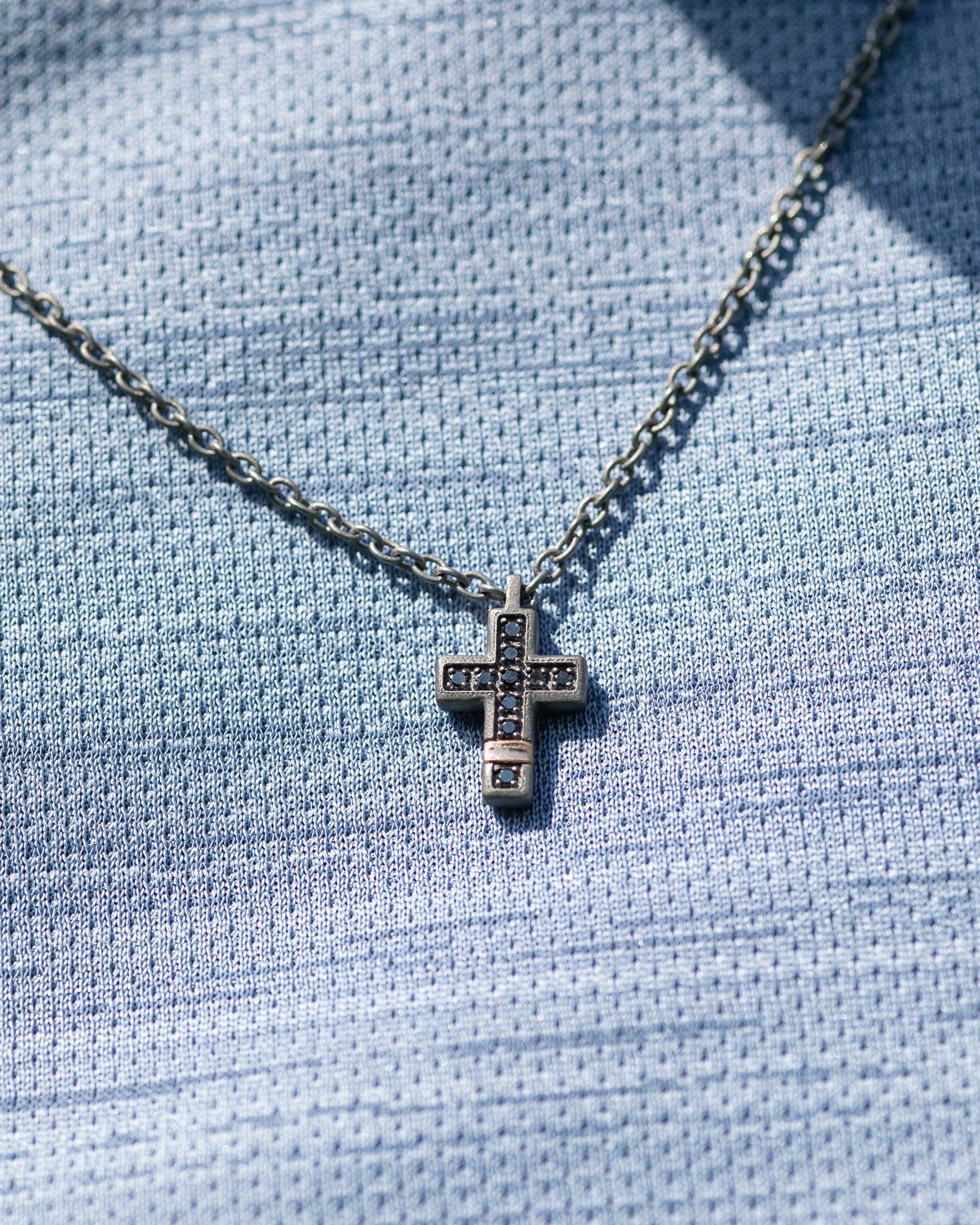 Titanium modern pendant is from our Men's Collection. The cross pendant is decorated by 10 natural round black diamonds in total of 0.10 Carat and with a 18K rose gold detail. The size of the cross is 1.5cm x 1 cm. The chain is 53cm long.  Perfect