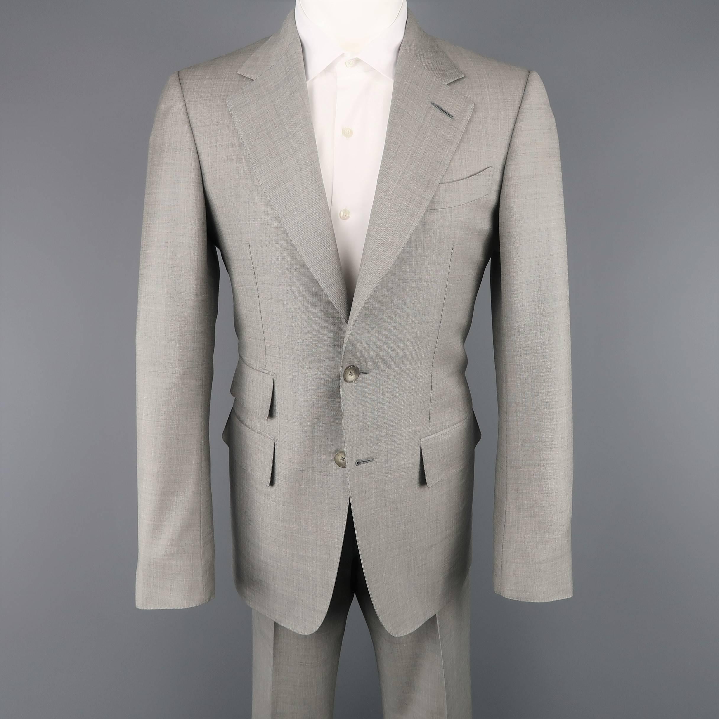 Custom Made Tom Ford suit comes in a light gray textured cool and includes a two button, single breasted sport coat with notch lapel, triple flap pocket, and functional button cuffs with matching flat front dress pants. Spot on jacket. As-is. Made