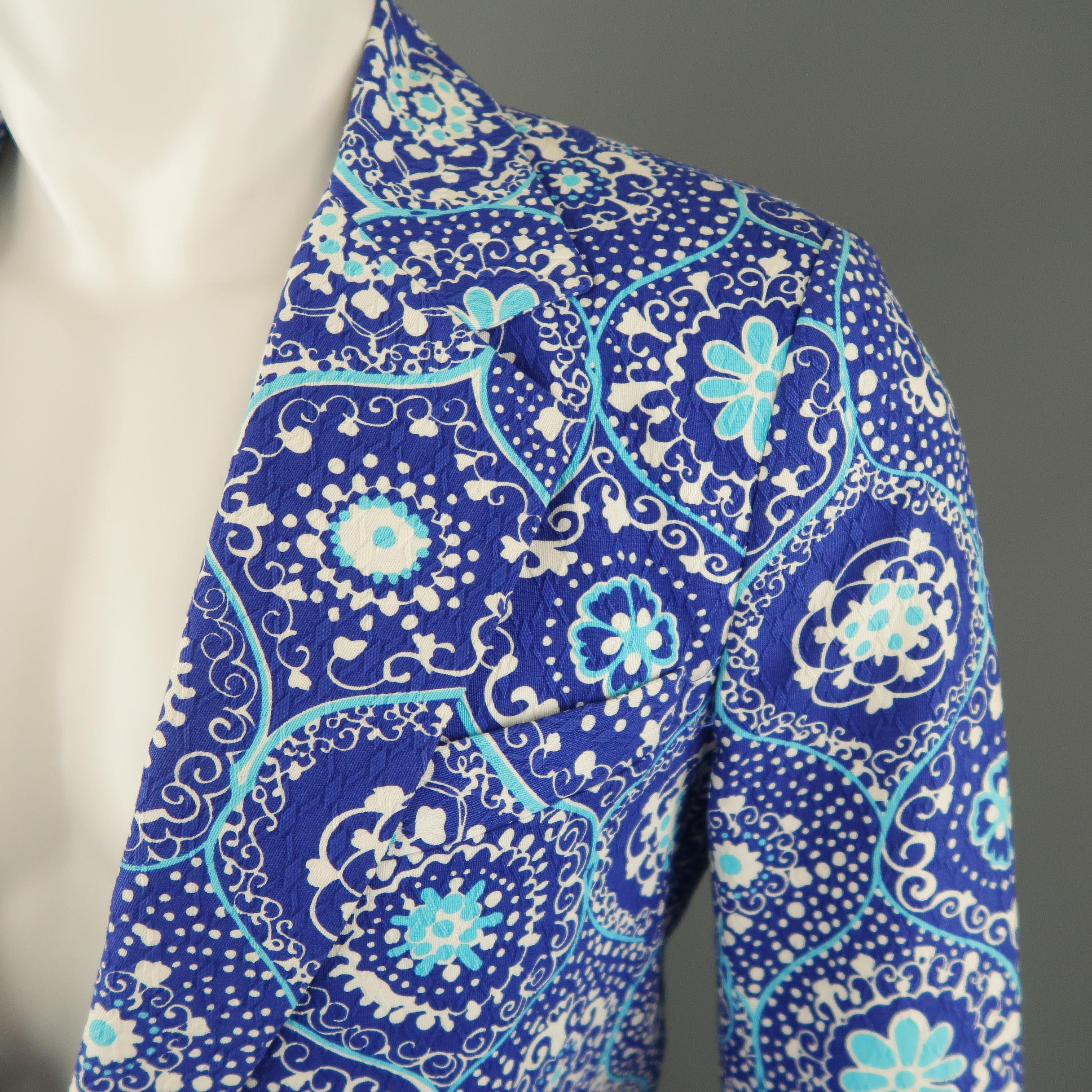 TRINA TURK sport coat comes in abstract blue, turquoise and white floral print textured cotton with a wide notch lapel, single breasted, two button front, and patch pockets. With tags. Made in USA.
 
Excellent Pre-Owned Condition.
Marked: 38
