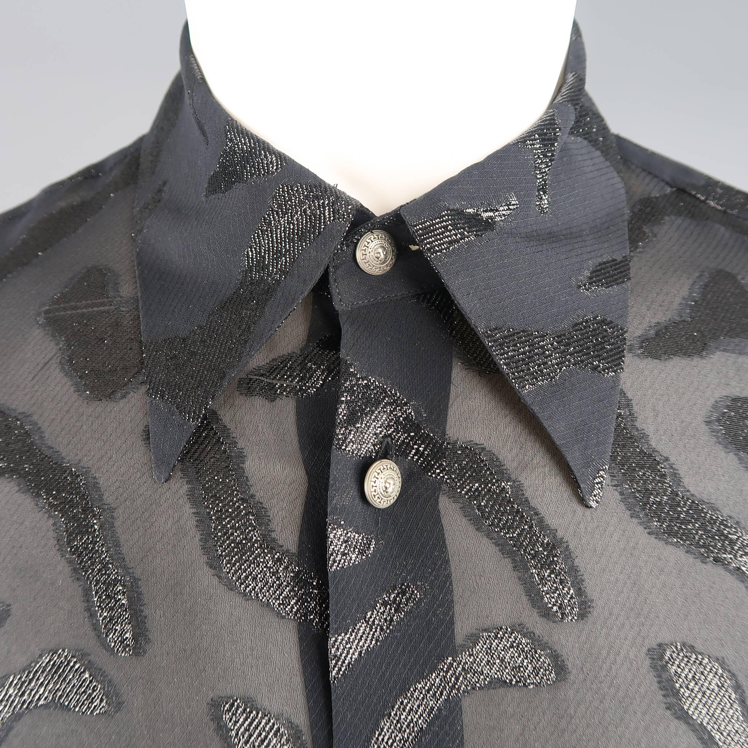 Vintage VERSUS by GIANNI VERSACE shirt comes in a black silk blend chiffon with all over metallic tiger burnout effect print with a pointed collar and silver tone lion head buttons. Minor wear. Made in Italy.
 
Good Pre-Owned Condition.
Marked: