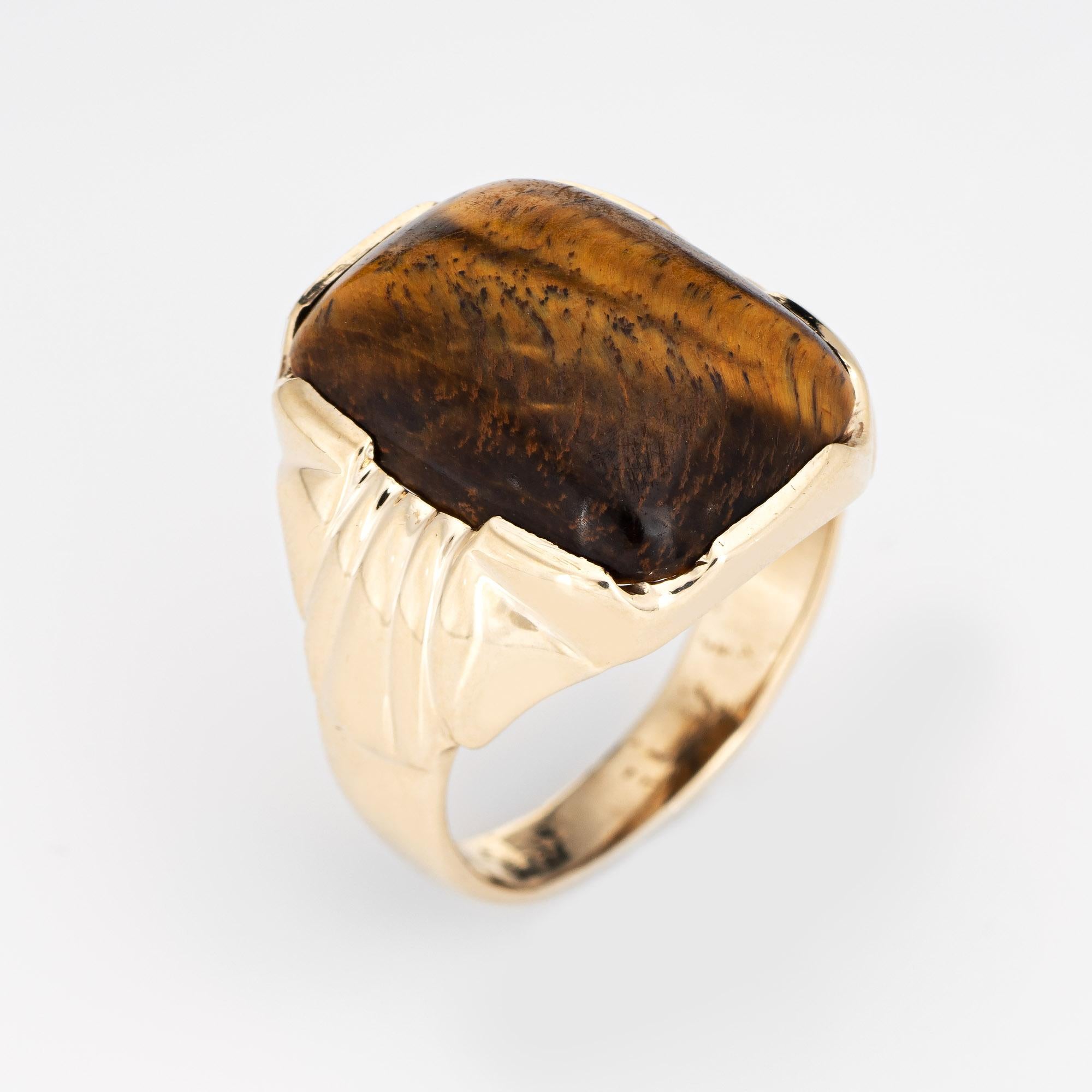 Stylish vintage men's tigers eye ring (circa 1970s) crafted in 10 karat yellow gold. 

Cabochon cut tigers eye measures 20mm x 15mm. The stone is in very good condition and free of cracks or chips. 

The luminous tigers eye shows golden flashes with