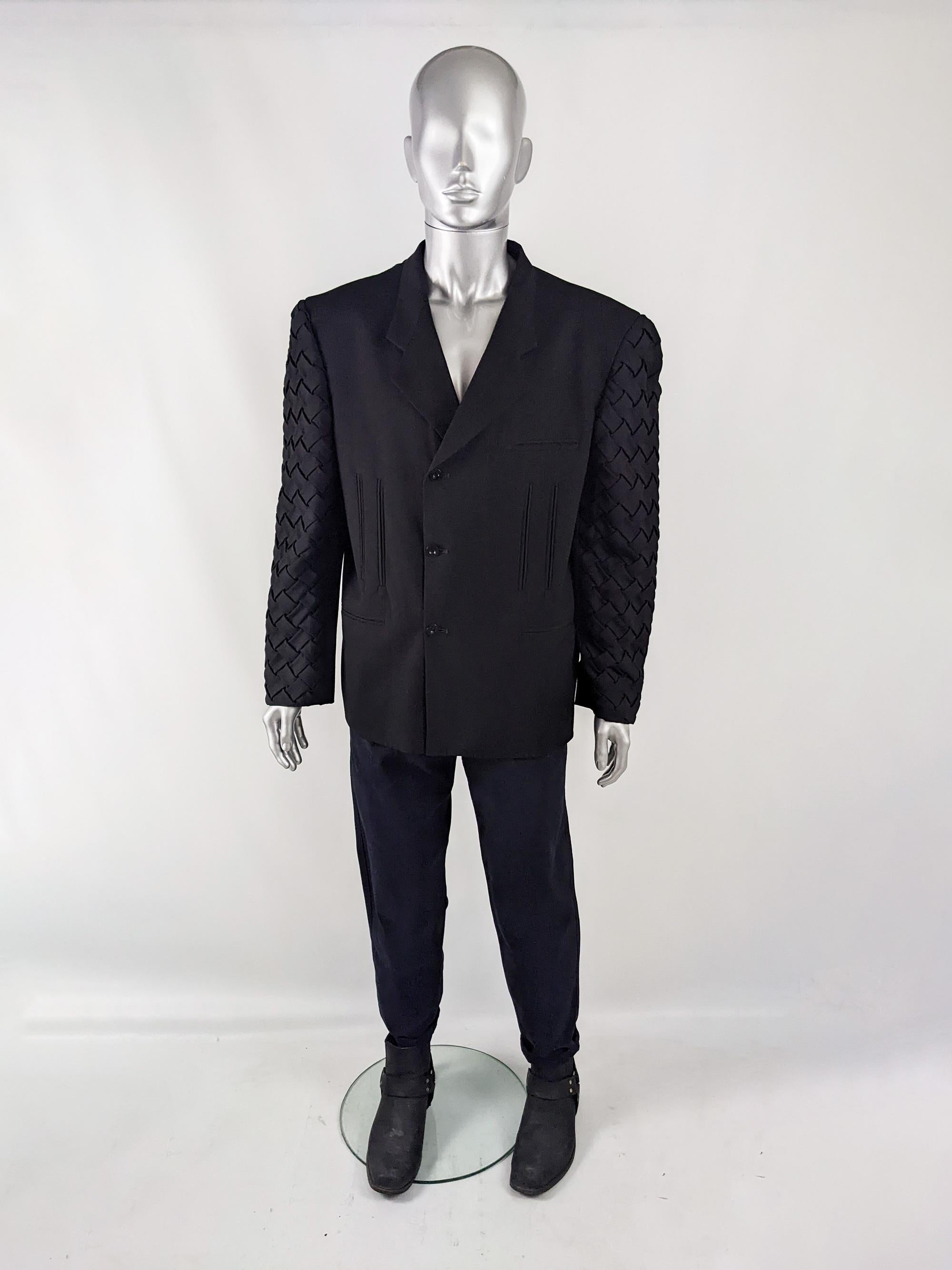 An incredible and avant garde mens jacket from the 80s by Greek designer, Gioni Garavanis. In a black fabric with amazing high fashion details from the wide shoulder pads giving a hyper masculine silhouette, the sleeves that have an incredible,