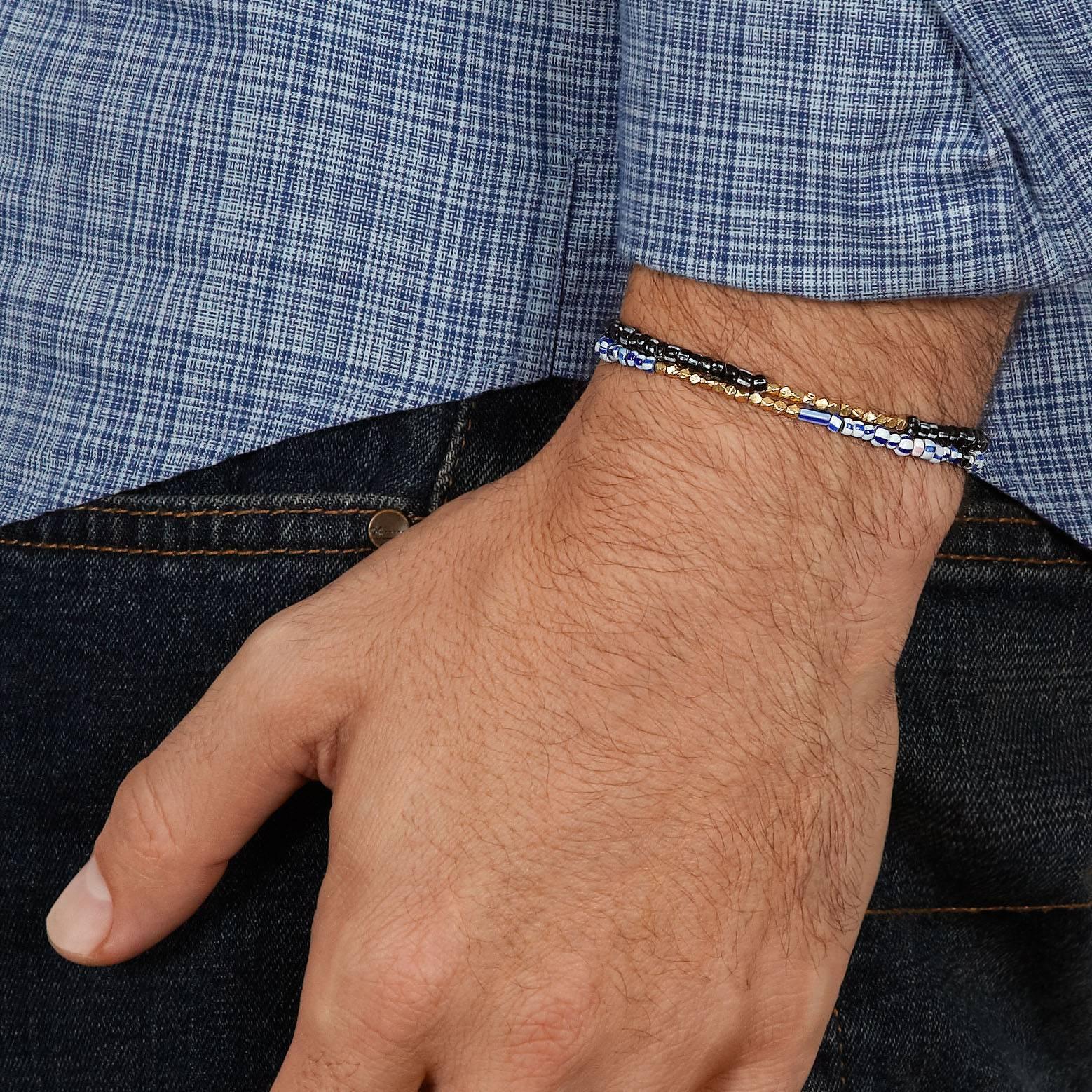 Dieses Armband besteht aus antiken gemischten blauen venezianischen Glasperlen, die mit einem Zoll massiven, gegossenen 14-karätigen Weißgoldperlen akzentuiert sind.  Die Struktur ist stark, gespannt und elastisch.

Diese antiken venezianischen