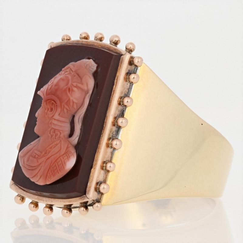 This vintage fashion ring features a superb design that is sure to impress!  The ring is set with a genuine sardonyx chalcedony gemstone atop the face of the yellow gold setting.  The gemstone has a rich burgundy hue and is carved with a warrior's