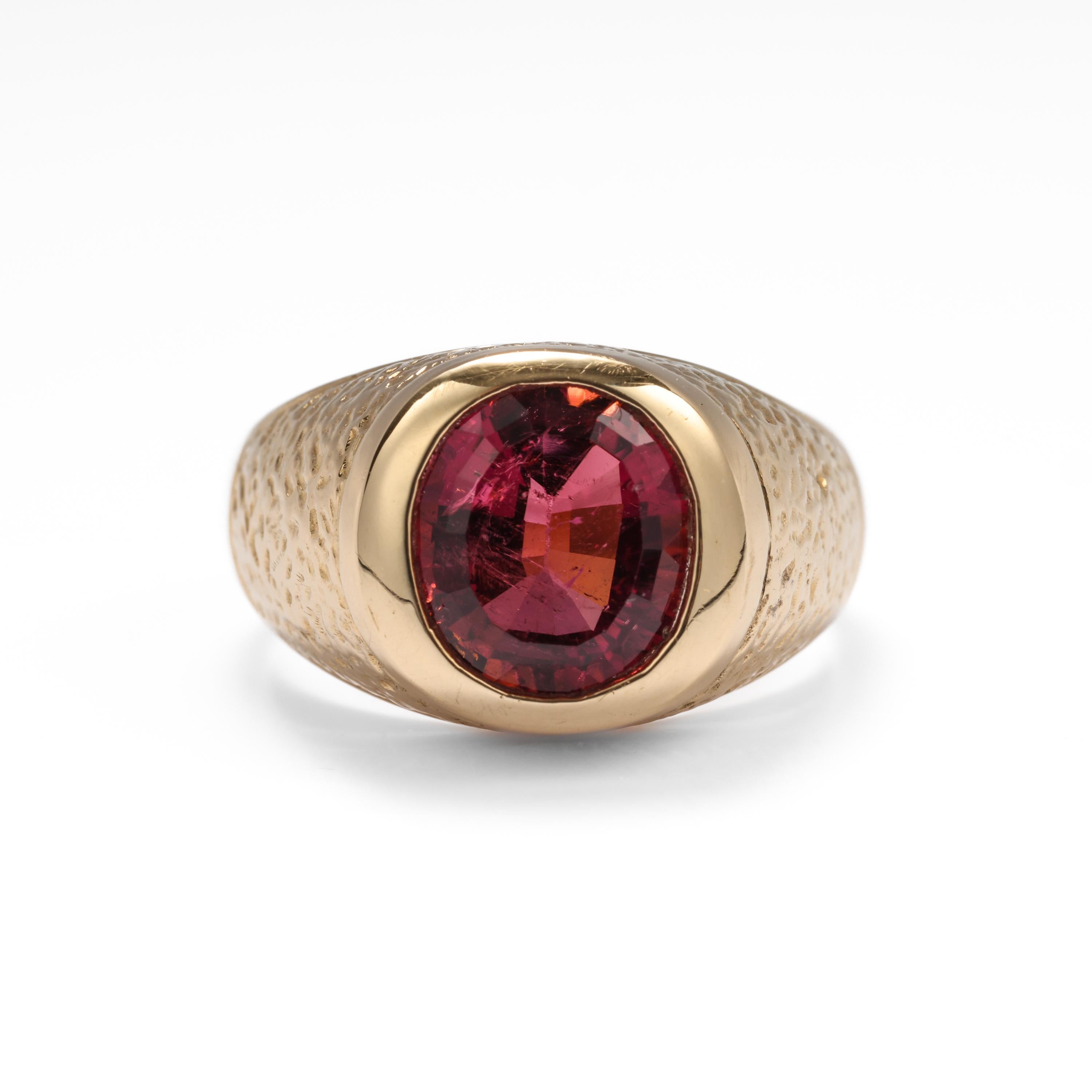 This is an impressive and substantial men's vintage tourmaline ring. The raspberry-red rubellite tourmaline ring is rendered in buttery yellow 18K gold, and weighs an impressive 12.33 grams. Dimpled detailing on both shoulders compliments the stone