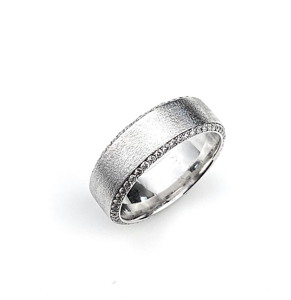Men's wedding band in 18kt white gold, set with white diamonds on both ring sides on beveled edges. Diamonds are F/G colour and VS/SI1 clarity.  Ring size 12. Finished on top surface with diamond finish.