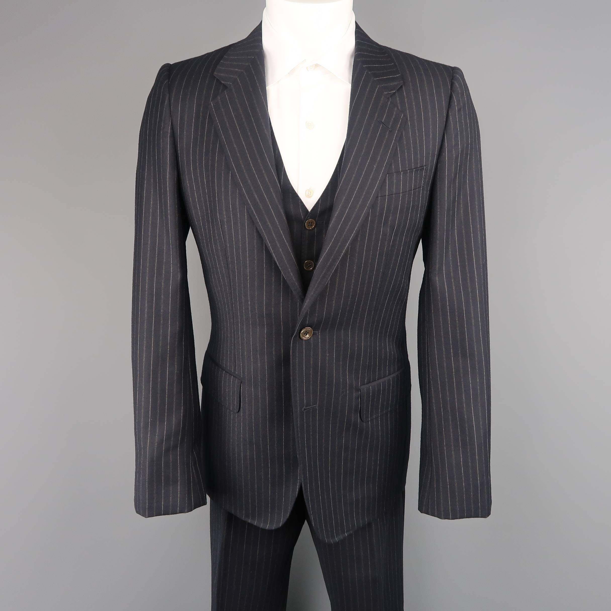 Three piece YVES SAINT LAURENT suit by TOM FORD comes in navy and grey pinstripe pattern wool and includes a single breasted, two button, notch lapel sport coat with button tab cuff, a V neck vest, and flat front trousers. Made in Italy.
 
Excellent