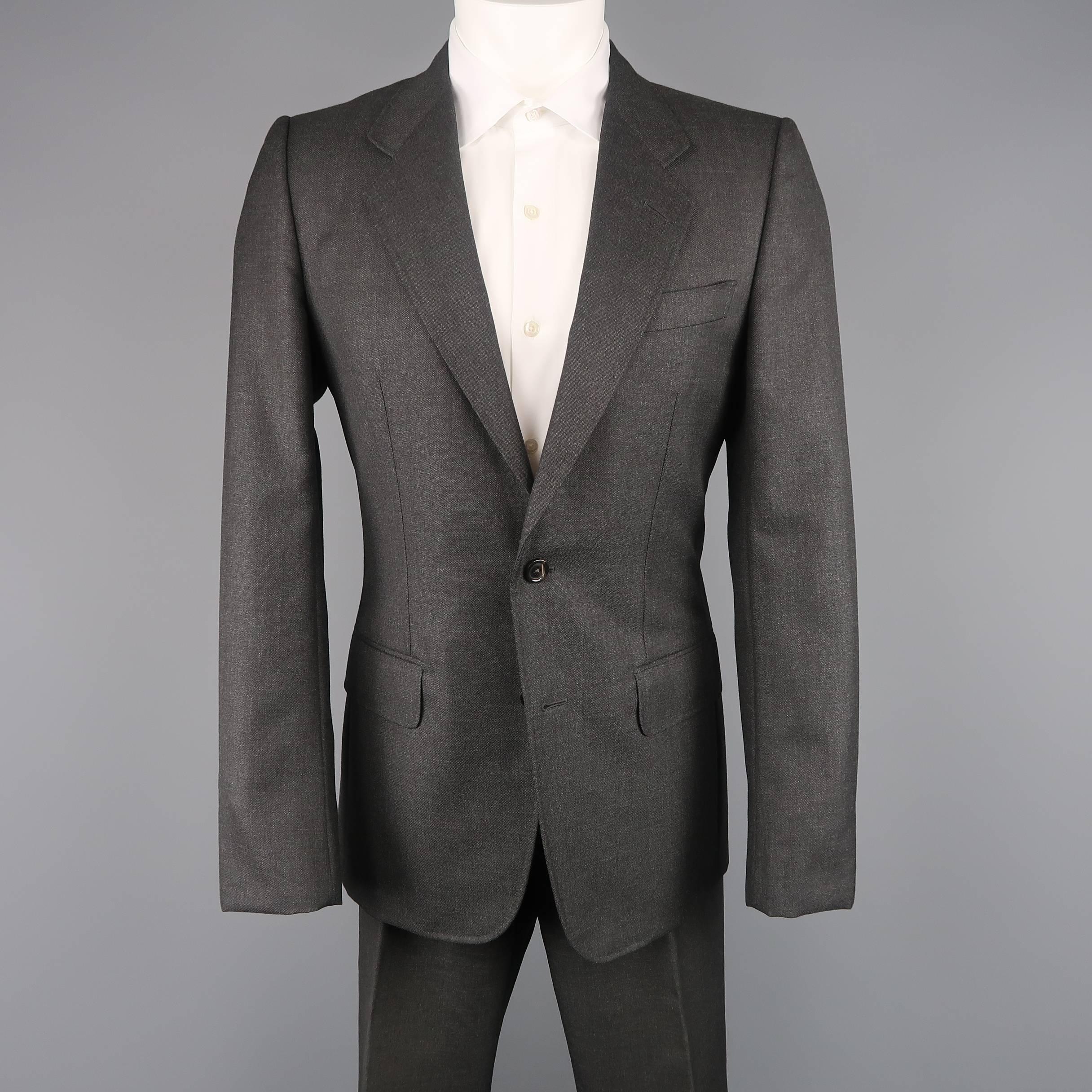 Two piece Yves Saint Laurent suit by Tom Ford comes in charcoal wool and includes a single breasted, two button sport coat with notch lapel and tab cuffs with matching flat front dress pants. Wear on pant liner. As is. Made in Italy.
 
Good