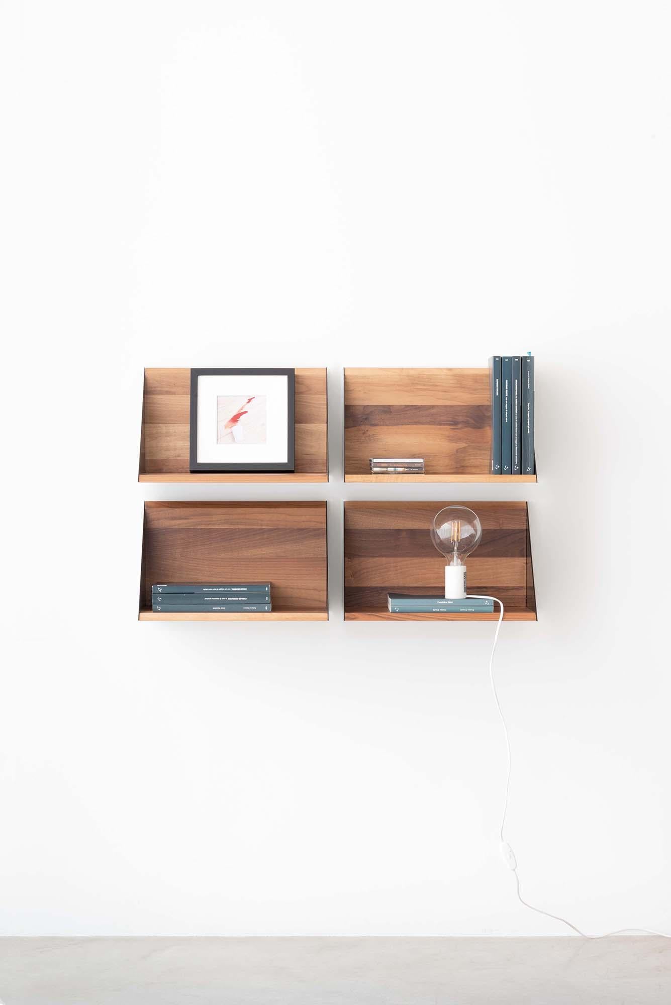 Shelf and back in walnut strips are held together by two thin triangular cheeks in painted metal.
The simple and primitive shape gives the shelf the opportunity to be used with various functions in the different areas of the house.
Solid wood is a