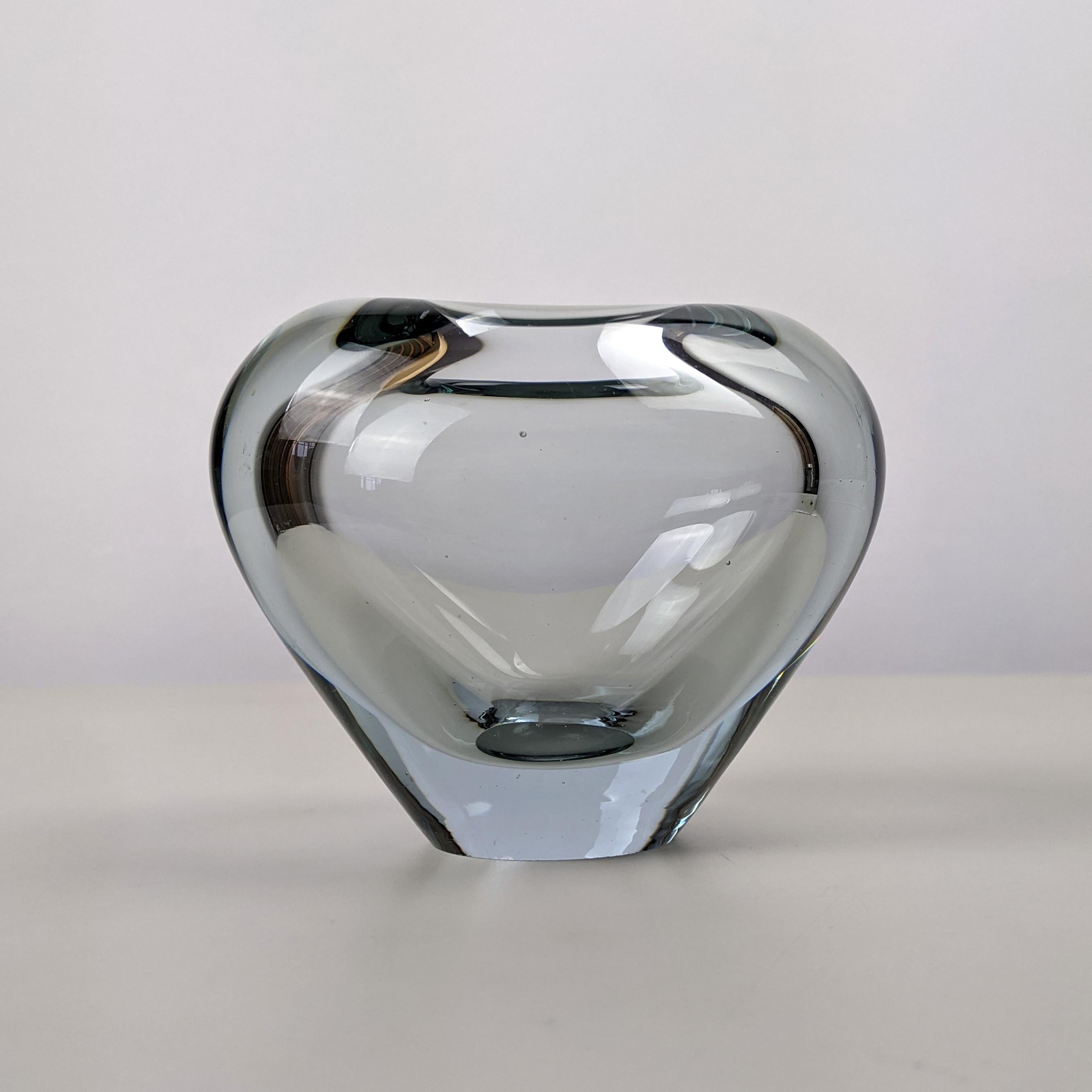 Per Lütken for Holmegaard
Heart-shaped vase from the 'Menuet' series, designed 1957, this example from 1961

Clear grey-blue tinted blown glass
Underside engraved 'PL 1961 Holmegaard'
Excellent condition

Dimensions, approx..:
Width 10.5cm,