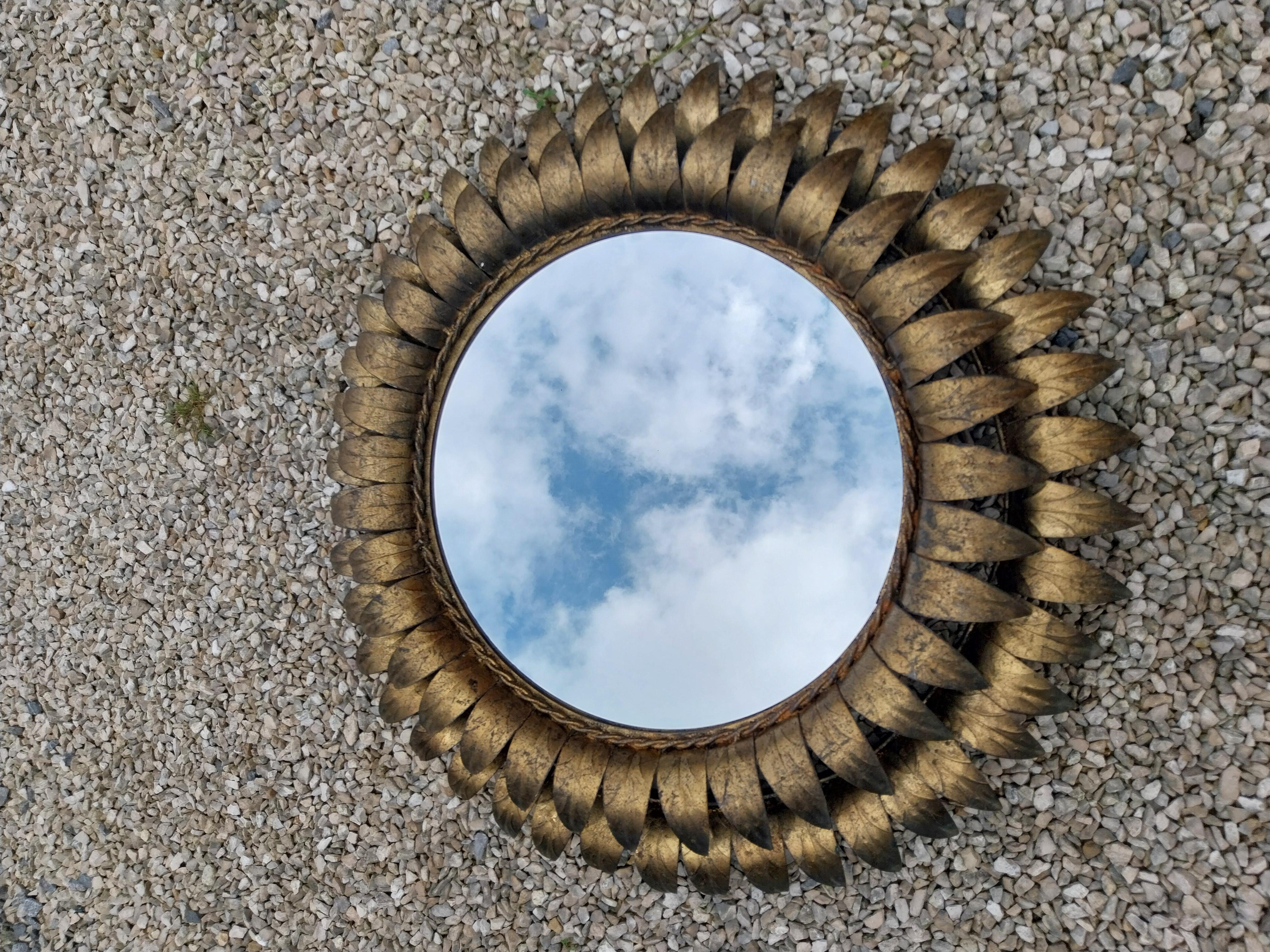 Unique sunburst mirror which is at the same time a sconce.
A double row of sunbeams above each other.

Cold painted metal frame: gold colour with a nice patina.

On the back you can find two fittings for the lamps, which have been rewired with a new