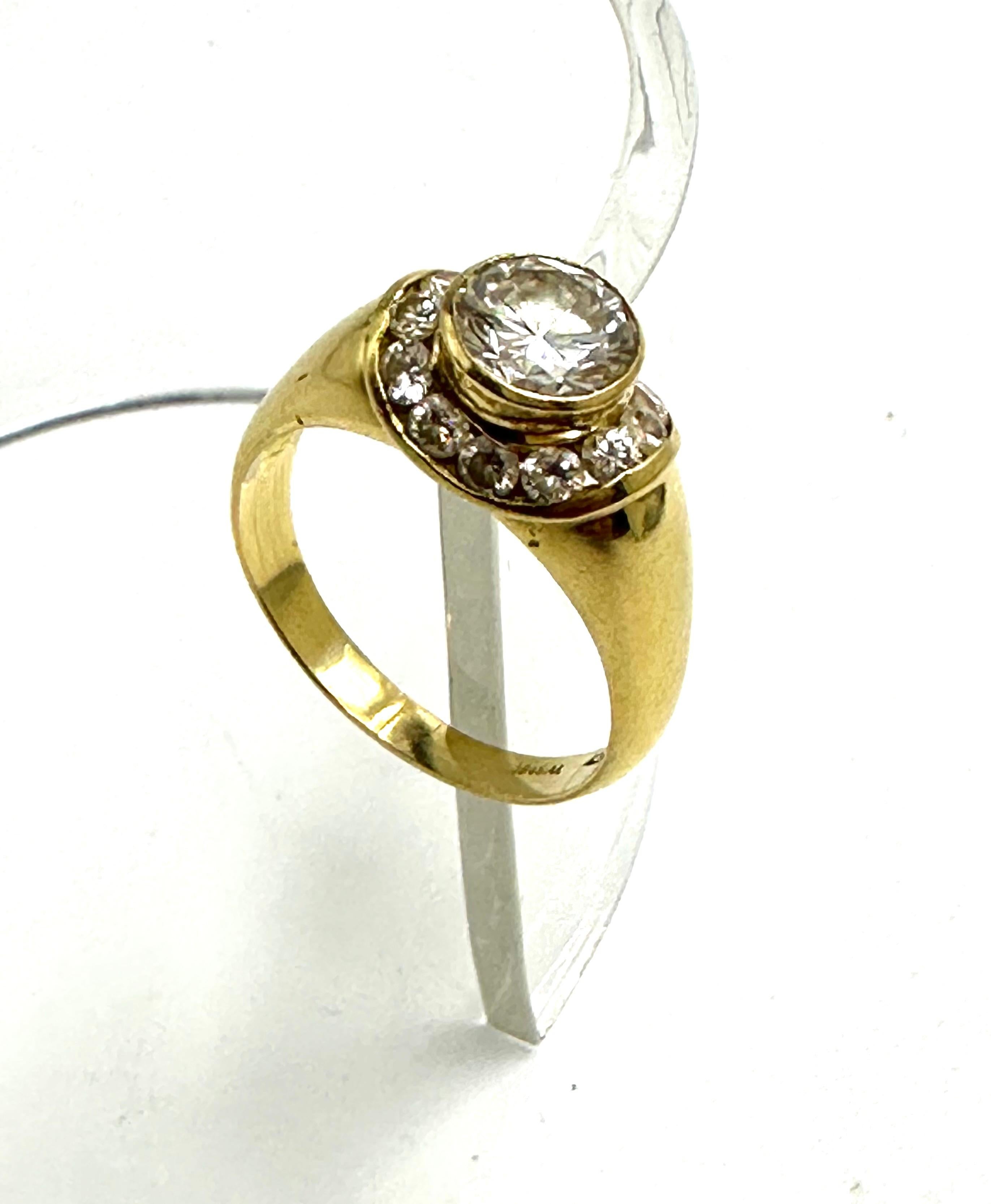 Exklusiver Ring, hergestellt in Italien aus 18 Karat Gelbgold.
Er trägt einen natürlichen Diamanten im Brillantschliff (1,25 ct. J VVS), der von weiteren natürlichen Diamanten (je 0,06 ct.) mit ähnlichen Farbmerkmalen umgeben ist.
Elegant und