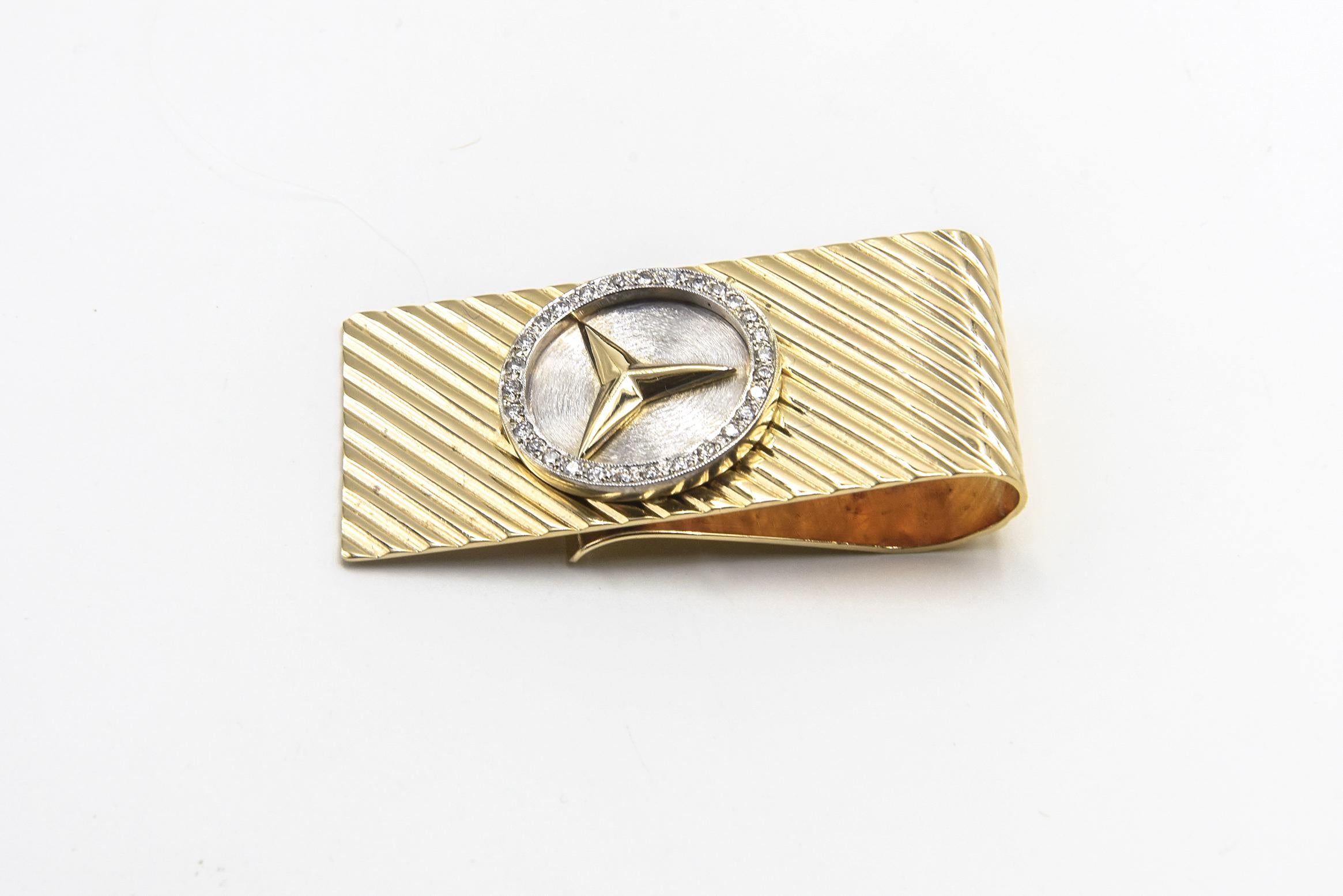 Mercedes Benz Diamond 14 Karat Yellow and White Gold Money Clip. The top of the clip has ribbed texture with raised diamond bezel and Mercedes Benz logo. The other side has a smooth shiny finish. The money clip measures approximately 1