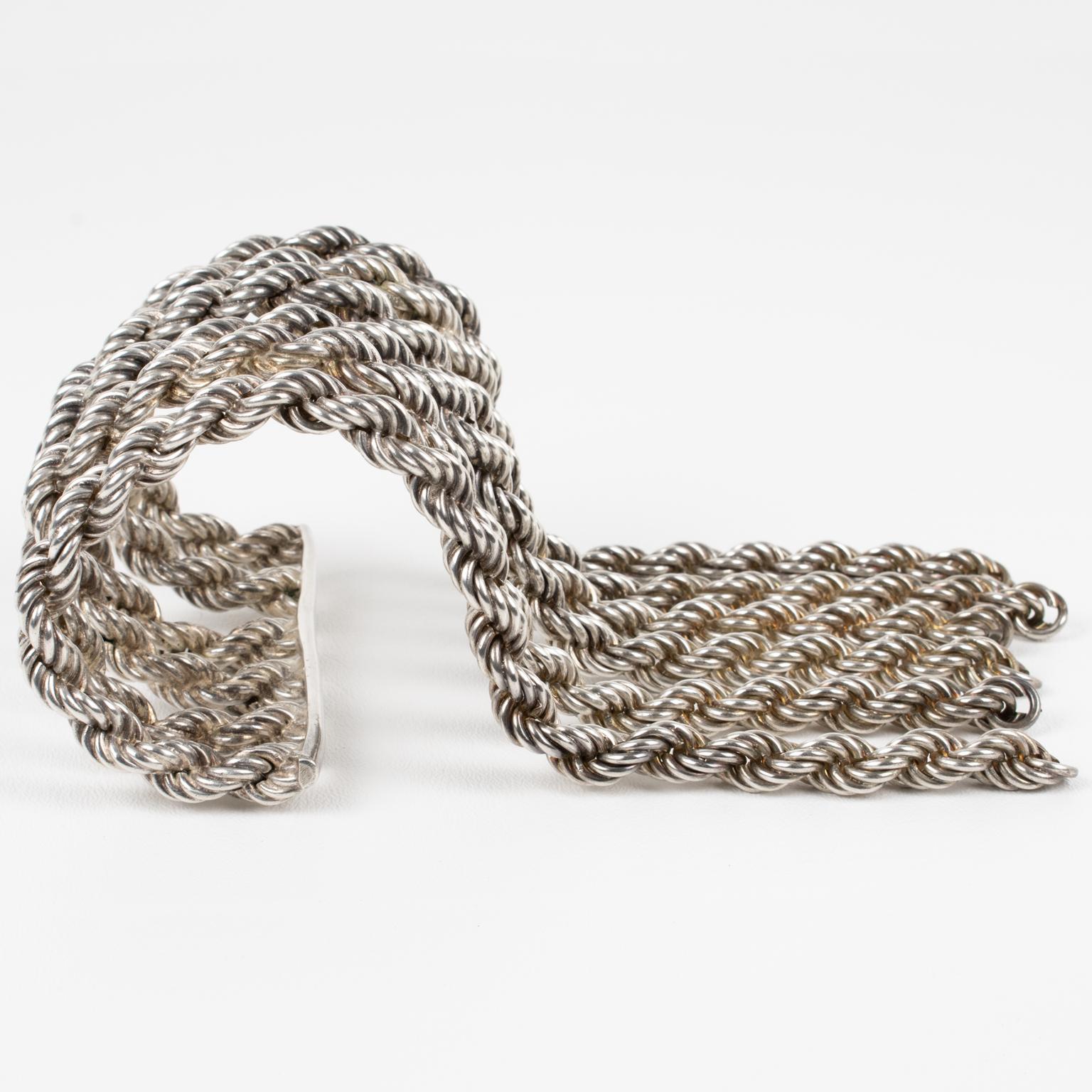 Dieses seltene und unglaubliche Manschettenarmband von Mercedes Robirosa Paris zeichnet sich durch eine versilberte Metallmanschette aus, die mit einer schweren Schlaufenkette versehen ist. 
Die Ketten, die dieses spektakuläre Armband formen, sind