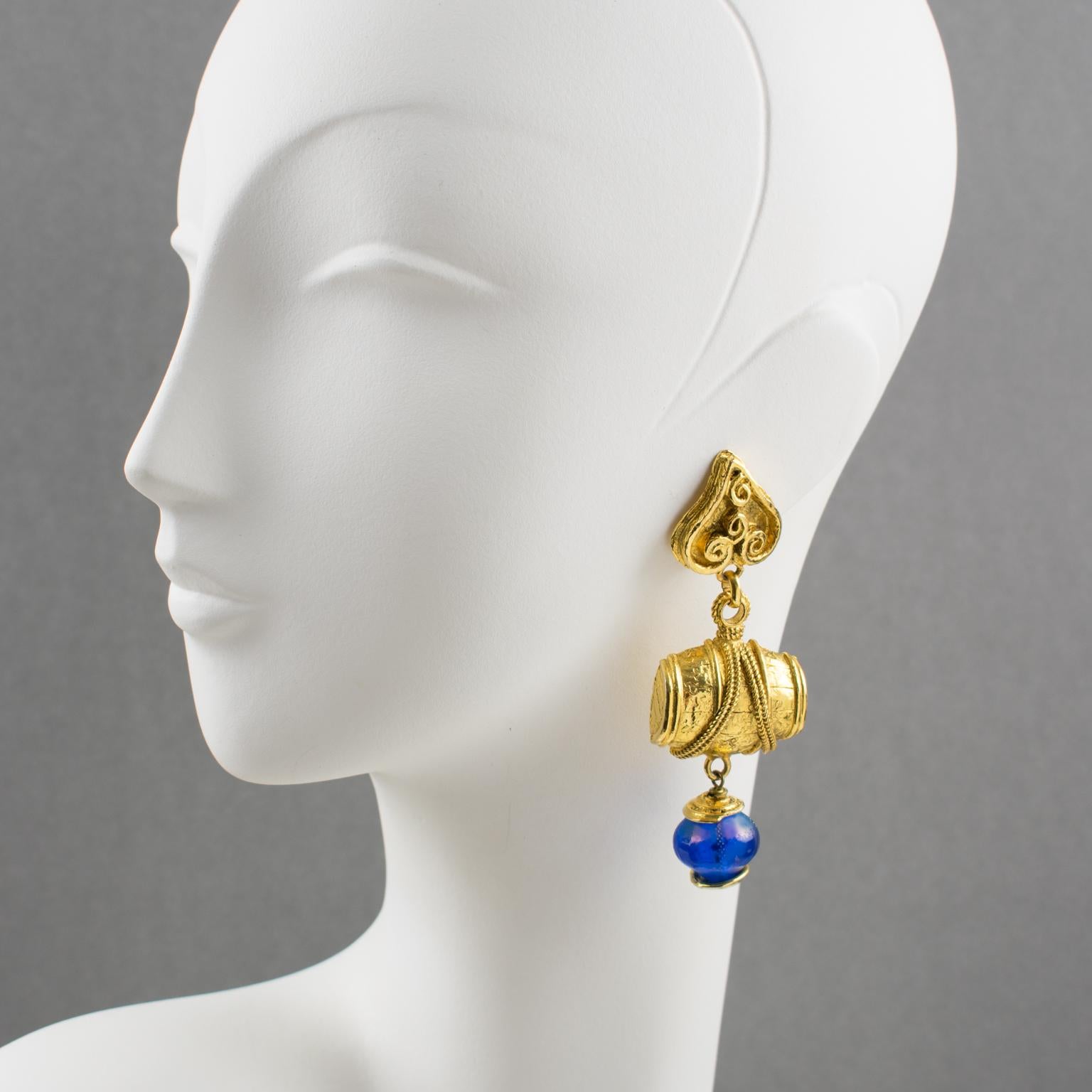 Ultra-chic Mercedes Robirosa Paris signed clip-on earrings. Oversized dangling baroque style with heart and barrel, gilt metal all textured compliment with cobalt blue resin bead. Signed at the back with the brand logo.
Measurements: 3.63 in. long