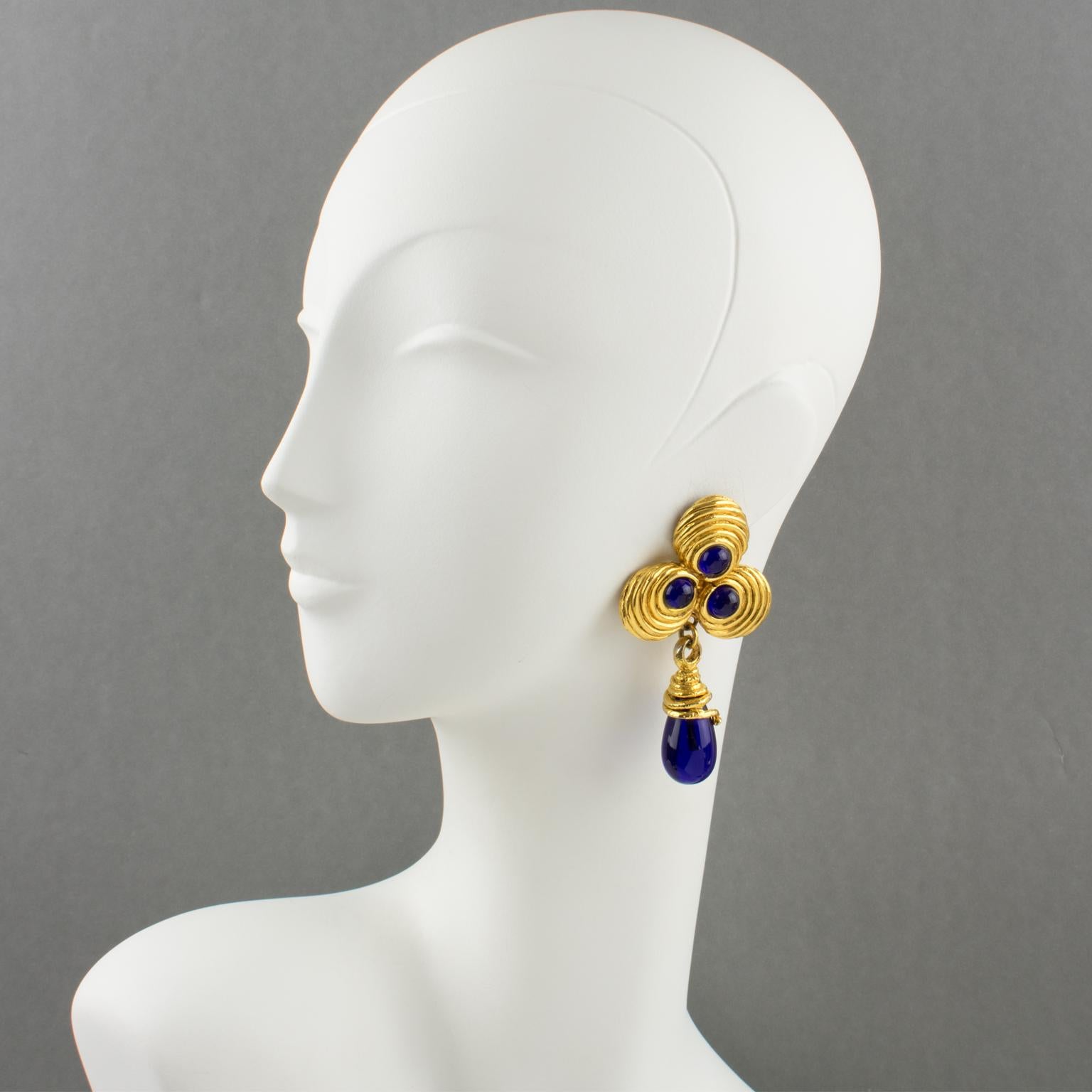 Ultra-chic Mercedes Robirosa Paris signed clip-on earrings. Oversized dangling baroque style with clover and teardrop, gilt metal all textured compliment with cobalt blue poured glass cabochons and drop. Signed at the back with the brand