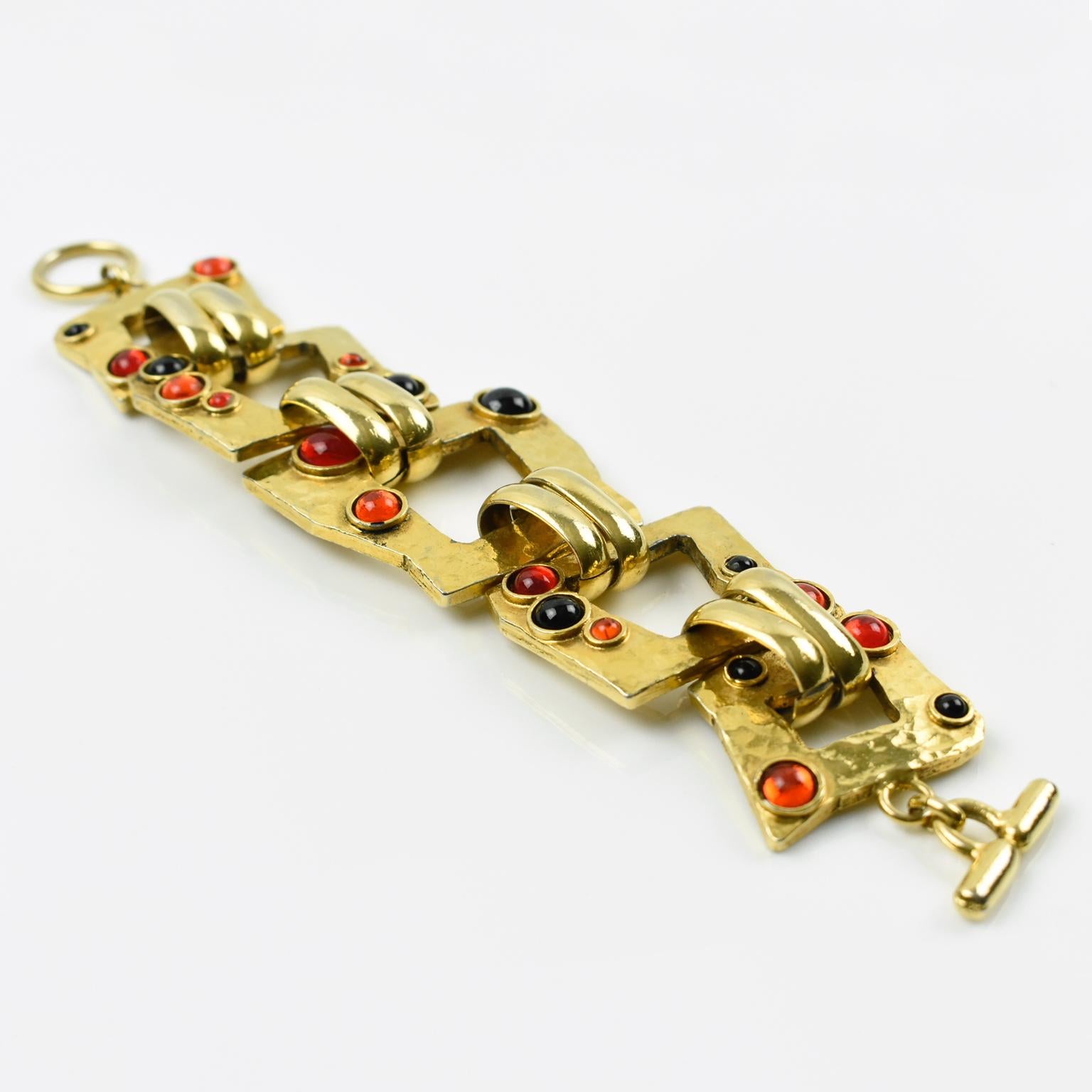Questo elegante bracciale a maglie di Mercedes Robirosa Paris è caratterizzato da uno stile fantasy modernista con ornamenti in metallo dorato e cabochon in cristallo rosso e nero Gripoix. Ha una chiusura ad alamaro e ogni maglia è firmata sul