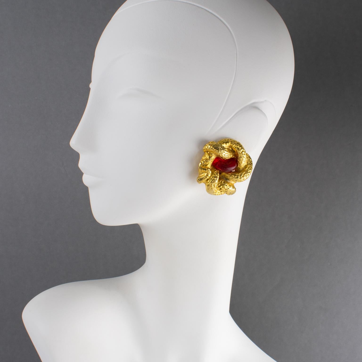 Mercedes Robirosa Paris ha disegnato questi rari orecchini a clip. I pezzi presentano una forma di serpente dimensionale sovradimensionata con un motivo intagliato, intricato e strutturato, impreziosito da un cabochon di resina rosso corniola. Un