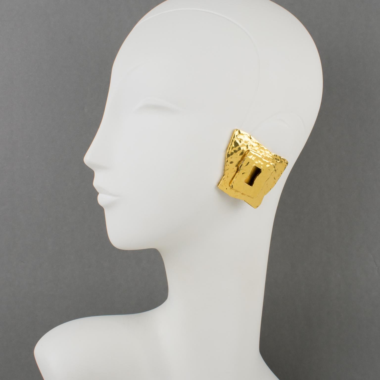 Very chic Mercedes Robirosa Paris clip-on earrings. Oversized modernist style with dimensional geometric shape featuring a sort of lock entry with gilt metal all textured and lightly hammered. Signed at the back with brand logo.
Measurements: 1.75